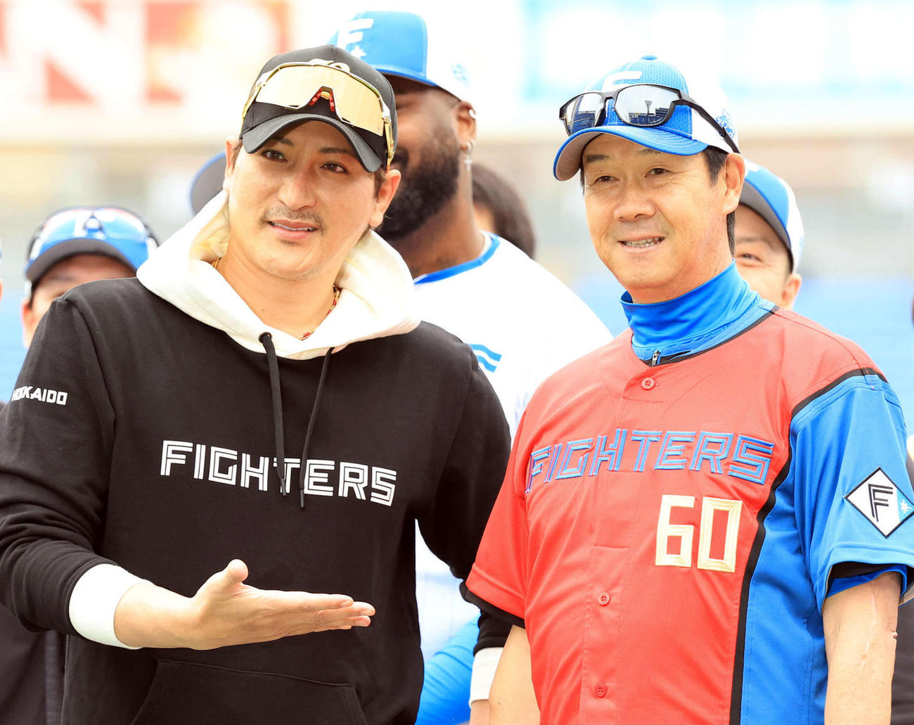 DeNA対日本ハム　試合前、この日60歳を迎えた日本ハム八木打撃コーチ（中央右）は赤いユニホームを贈られ、新庄監督（同左）ら選手たちと記念撮影（撮影・浅見桂子）