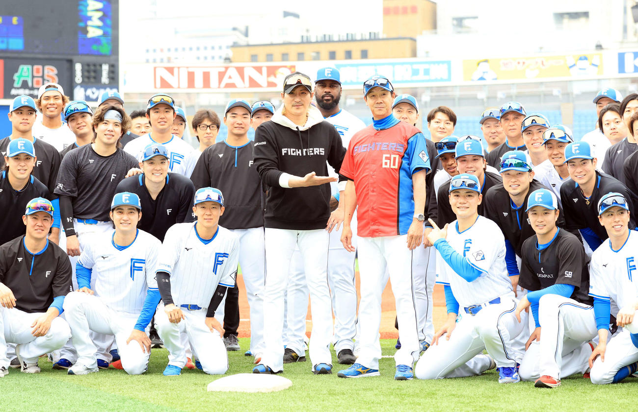 DeNA対日本ハム　試合前、この日60歳を迎えた日本ハム八木打撃コーチ（中央右）は赤いユニホームを贈られ、新庄監督（同左）ら選手たちと記念撮影（撮影・浅見桂子）
