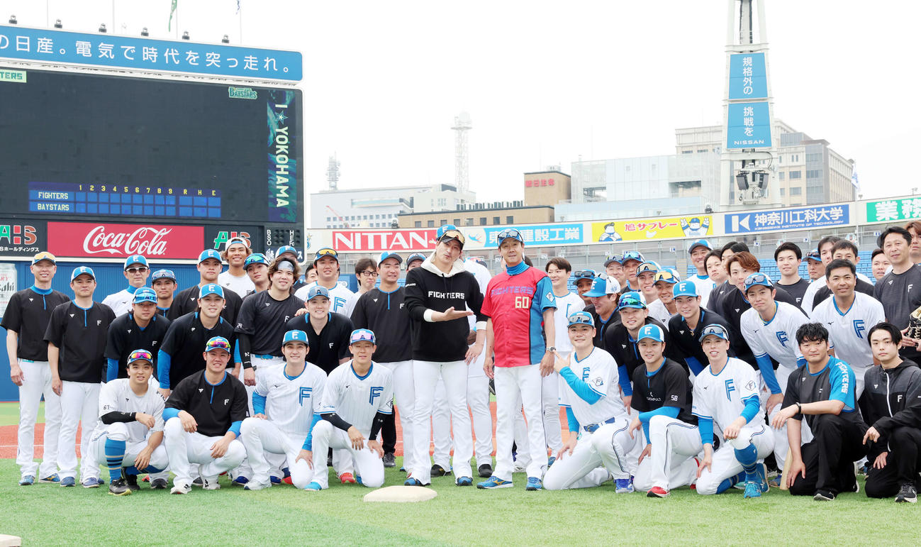 DeNA対日本ハム　試合前、この日60歳を迎えた日本ハム八木打撃コーチ（中央右）は赤いユニホームを贈られ、新庄監督（同左）ら選手たちと記念撮影（撮影・浅見桂子）