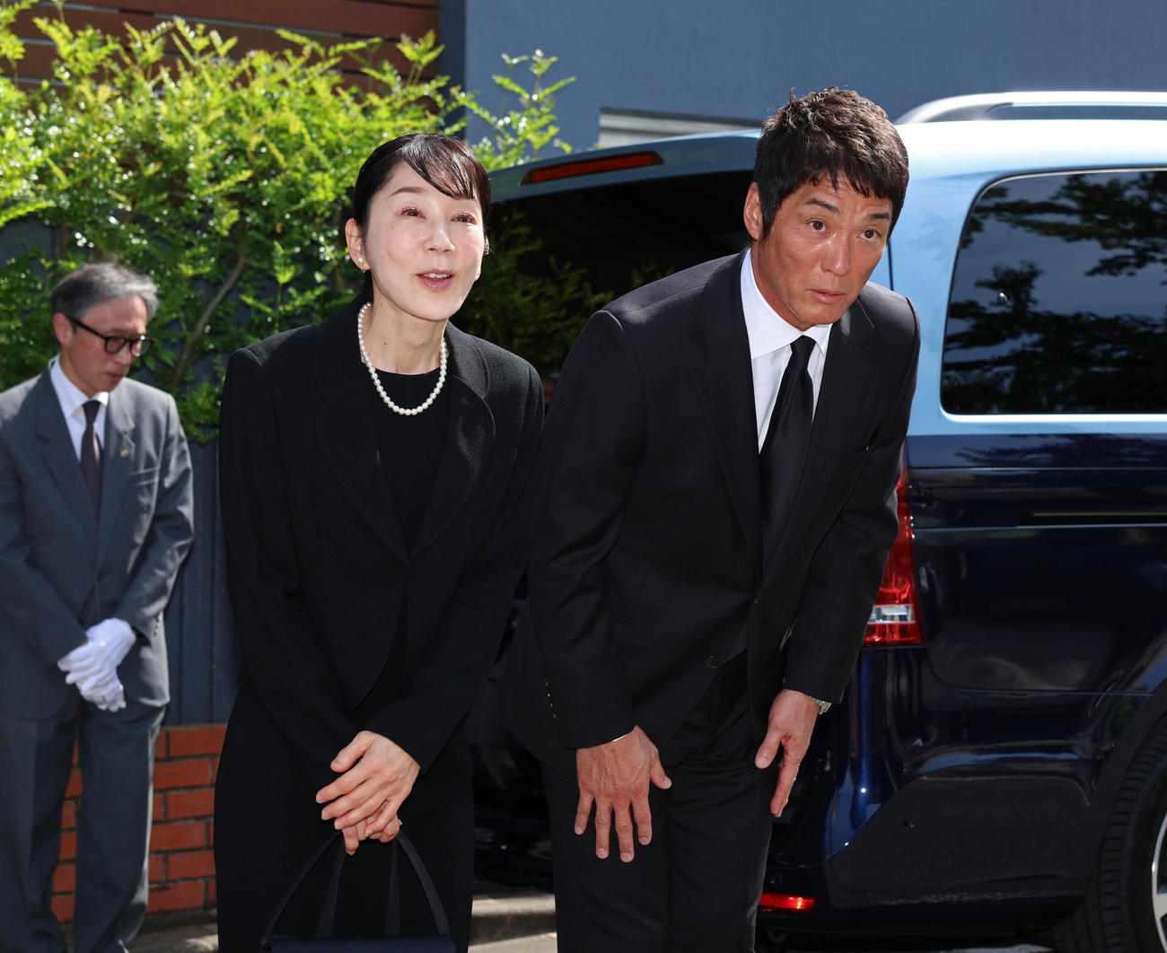 自宅前で一礼する長嶋一茂氏（右）、三奈氏（読売新聞社提供）