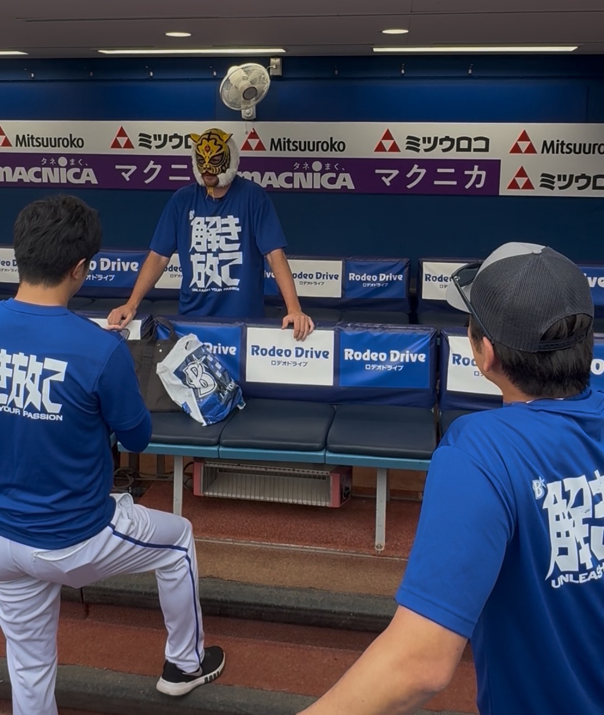 ハマスタに来場した新日本プロレスのタイガーマスクにマスクを借りてかぶるDeNAバウアー（奥）と、それを見守る三浦監督（右手前）（撮影・小早川宗一郎）