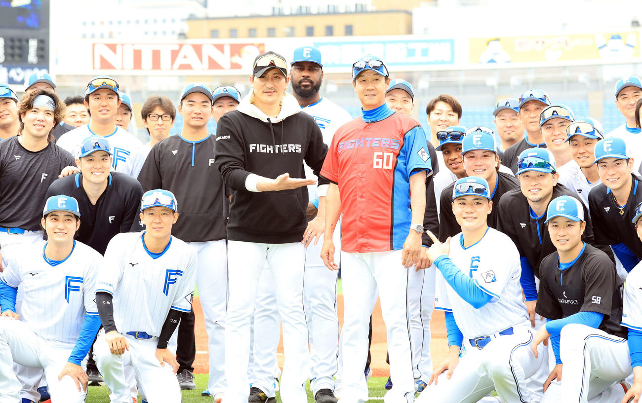 DeNA対日本ハム　試合前、この日60歳を迎えた日本ハム八木打撃コーチ（中央右）は赤いユニホームを贈られ、新庄監督（同左）ら選手たちと記念撮影（撮影・浅見桂子）
