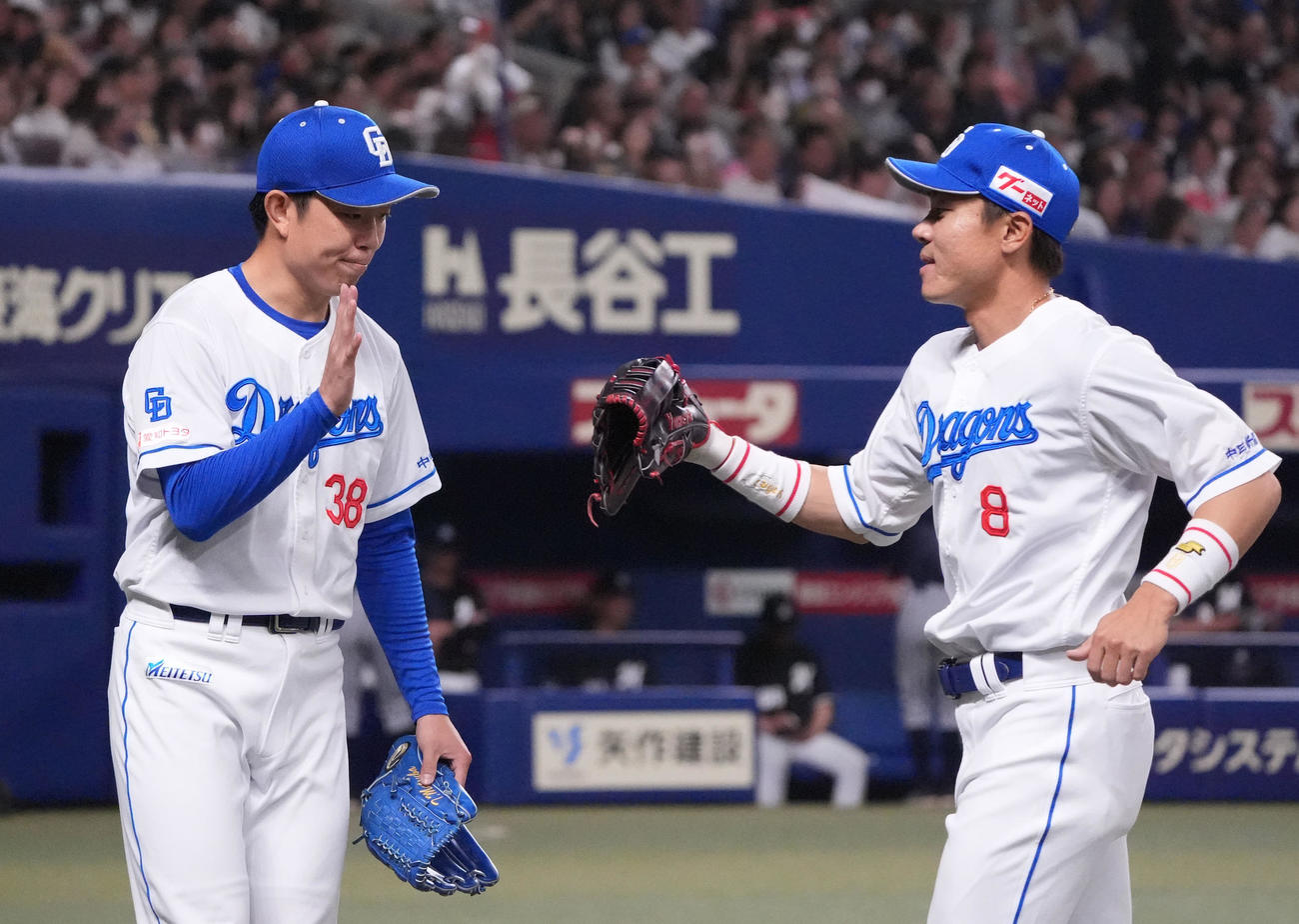 中日対ロッテ　1回表終了、好守を見せた大島（右）とタッチを交わす松葉（撮影・森本幸一）
