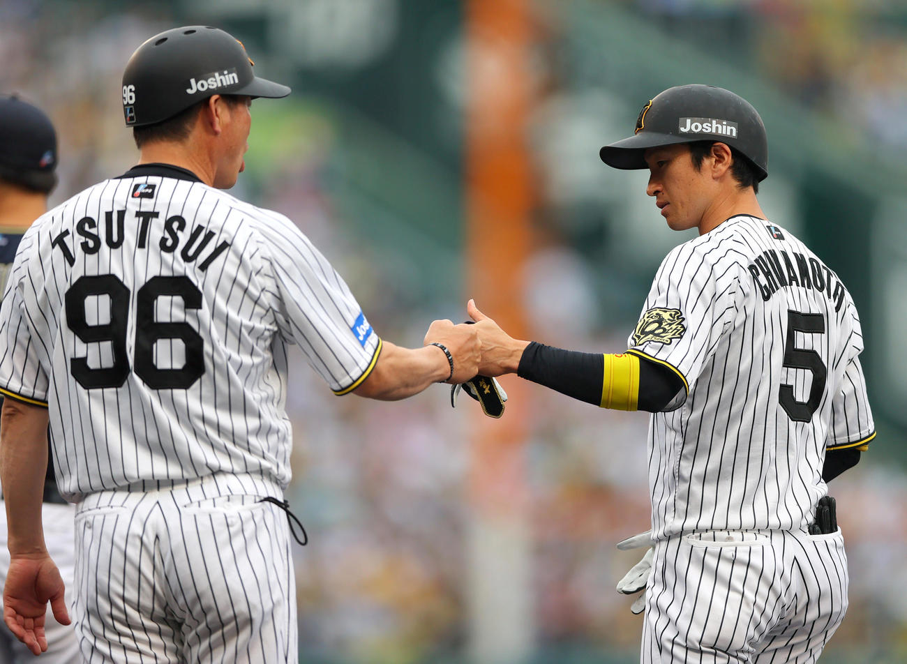 近本は中前打を放ち筒井外野守備兼走塁チーフコーチとタッチをかわす（撮影・上山淳一）