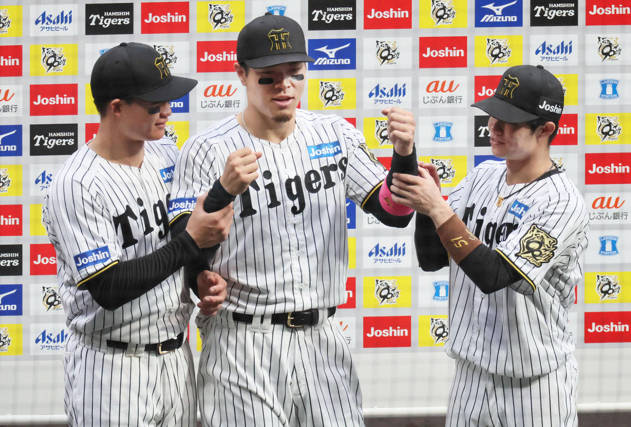 阪神対オリックス　お立ち台で両腕を上げようとする森下（左）と中野（右）の動きを拒否する佐藤輝（撮影・宮崎幸一）