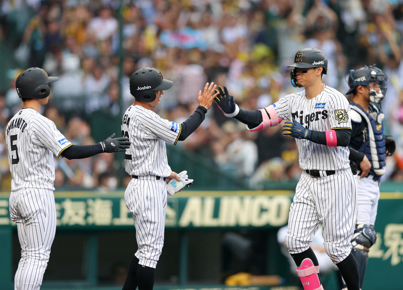 阪神対オリックス　8回裏阪神1死満塁、佐藤輝（右から2人目）は中越え満塁本塁打を放ち生還する（撮影・上山淳一）