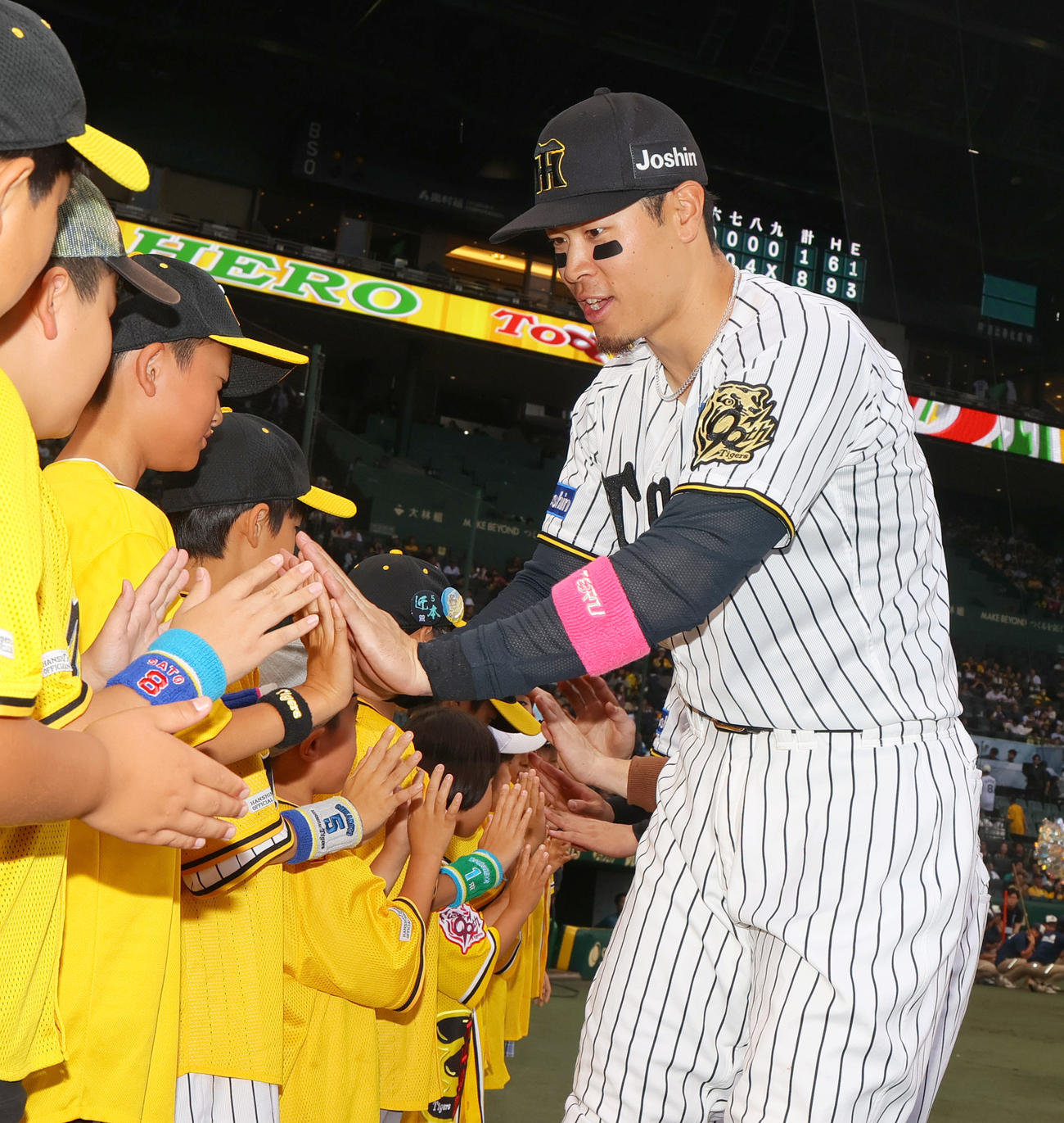 阪神対オリックス　オリックスに勝利し、児童らとタッチをかわすヒーローの佐藤輝（撮影・上山淳一）