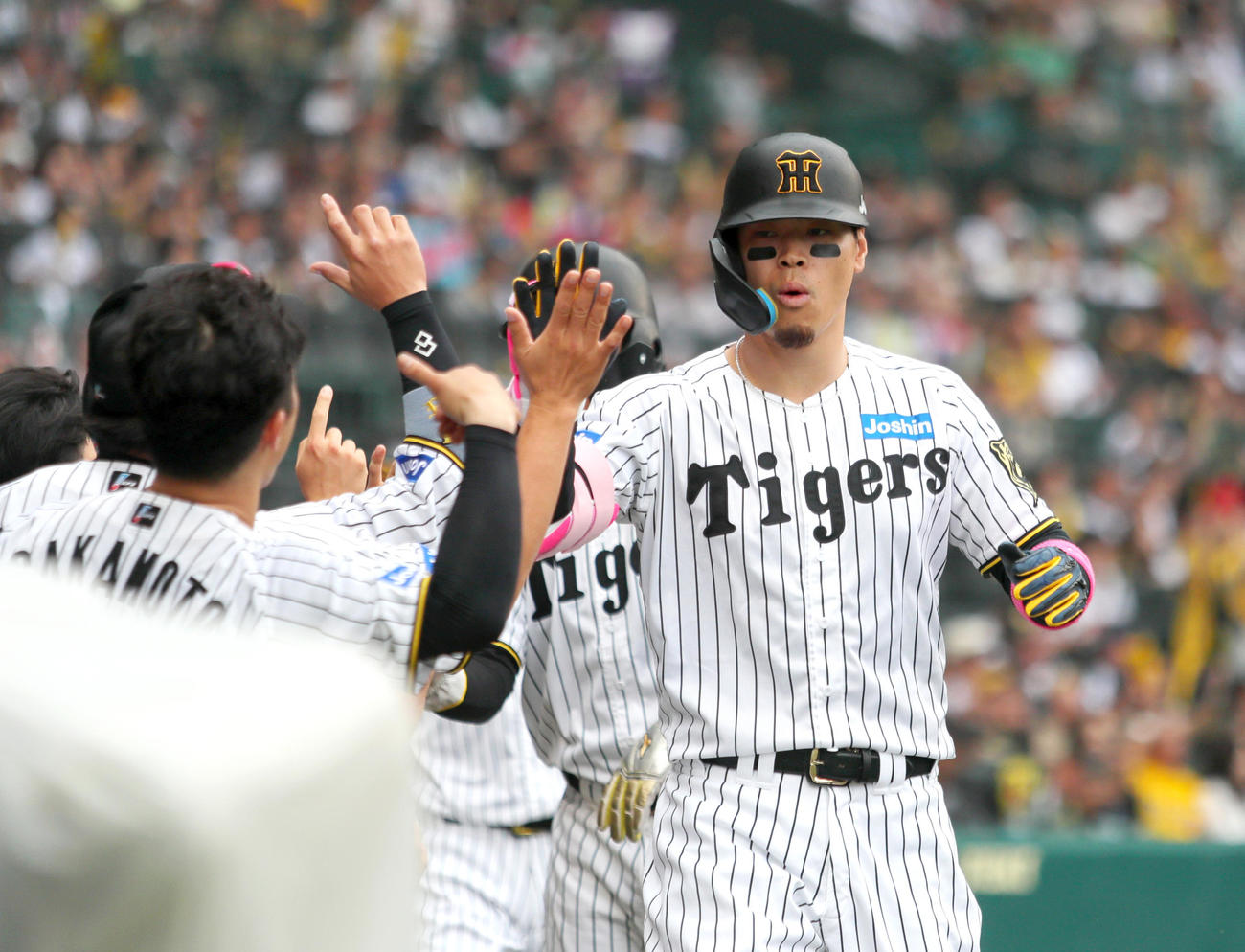 阪神対オリックス　8回裏阪神1死満塁、佐藤輝（右）は中越え満塁本塁打を放ち祝福を受ける（撮影・上山淳一）