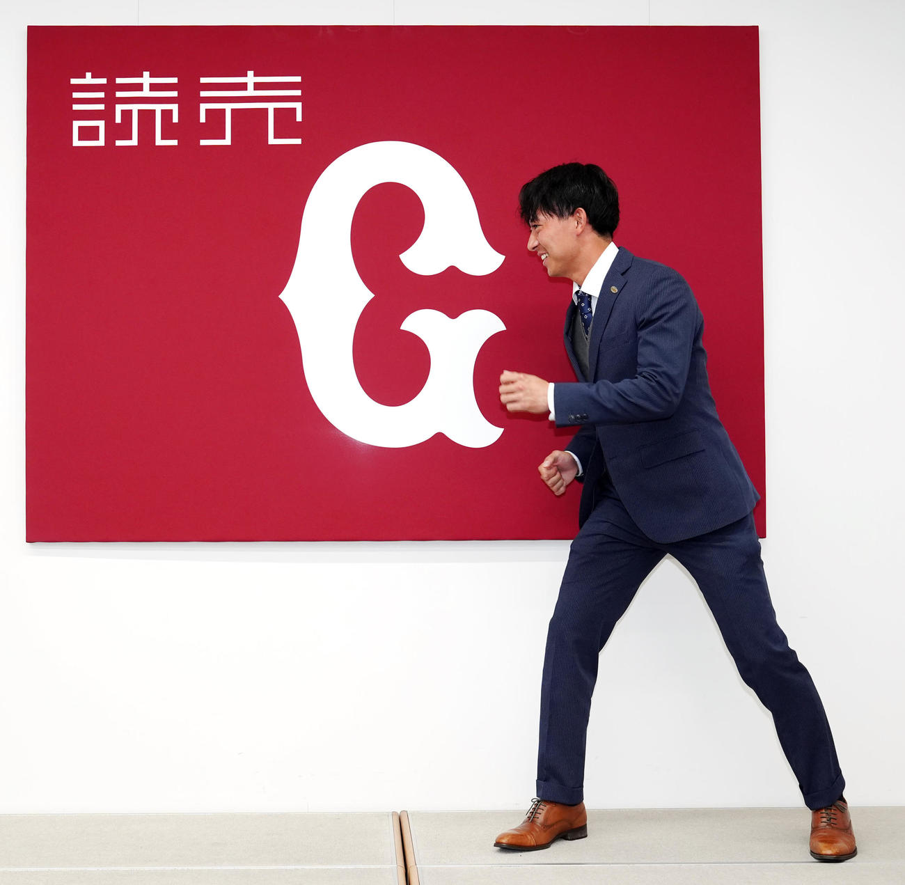 支配下登録で会見に臨み、カメラマンの要望で走るポーズを思案する巨人鈴木大（撮影・江口和貴）