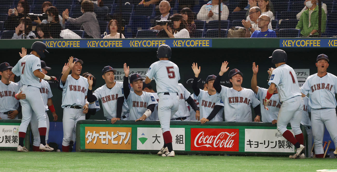 神奈川大対近大　2回裏近大2死満塁、阪上の中越え適時二塁打で生還した走者を出迎えるナイン（撮影・柴田隆二）