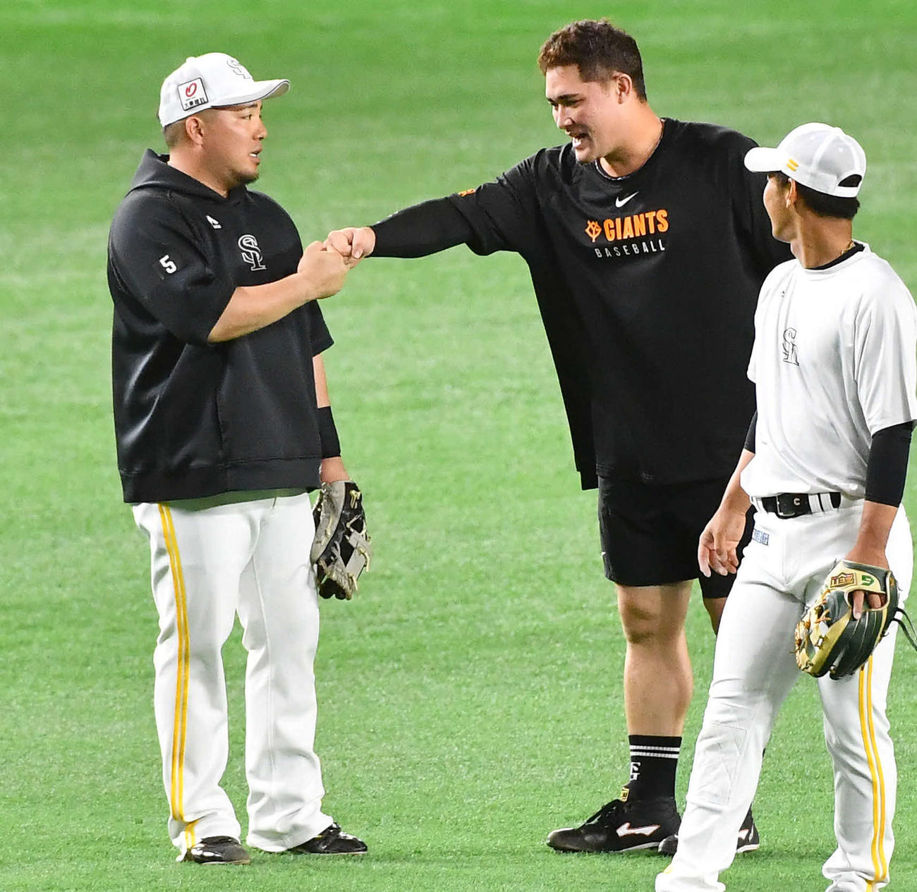 ソフトバンク対巨人　試合前、ソフトバンク山川（左）とグータッチを交わす巨人リチャード（撮影・岩下翔太）