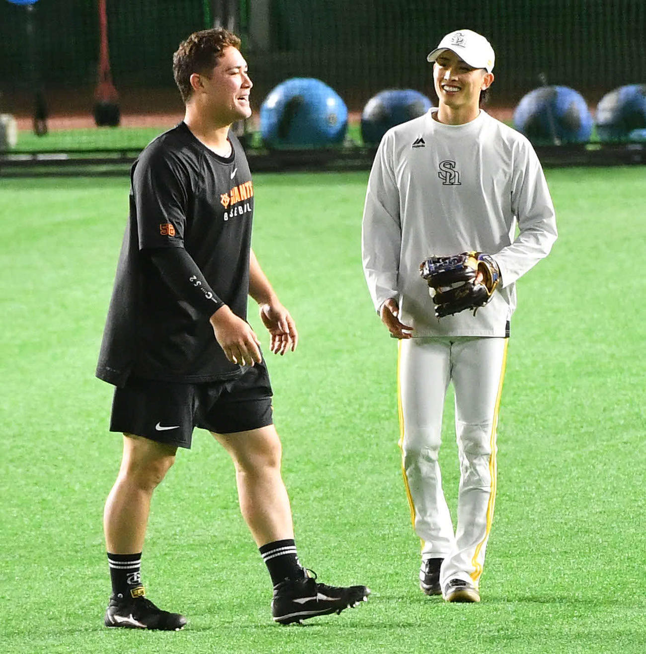 ソフトバンク対巨人　試合前、巨人リチャード（左）と談笑するソフトバンク周東（撮影・岩下翔太）