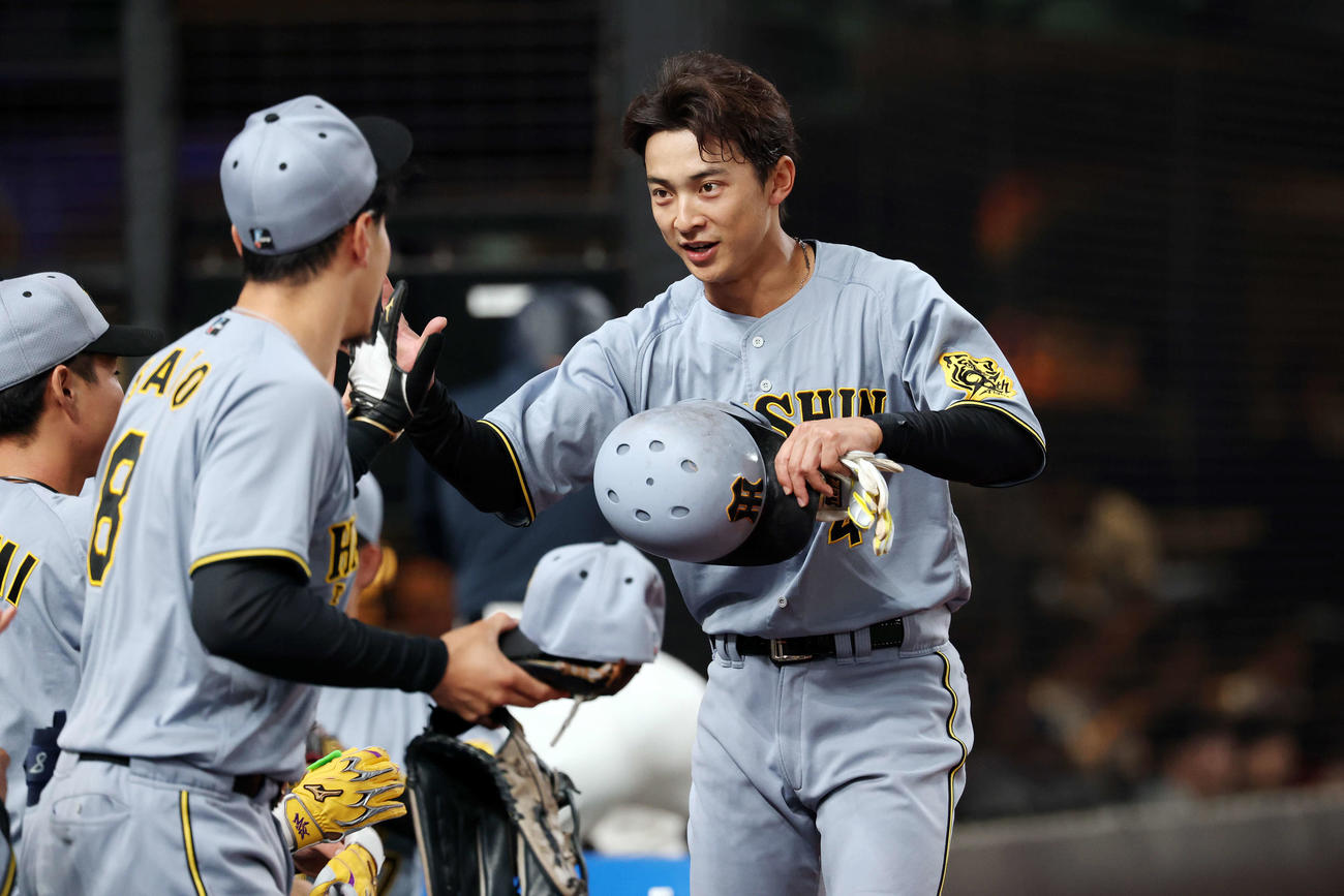 西武対阪神　2回表阪神2死一、三塁、先制適時打を放った熊谷はチームメートとを交わす（撮影・宮地輝）