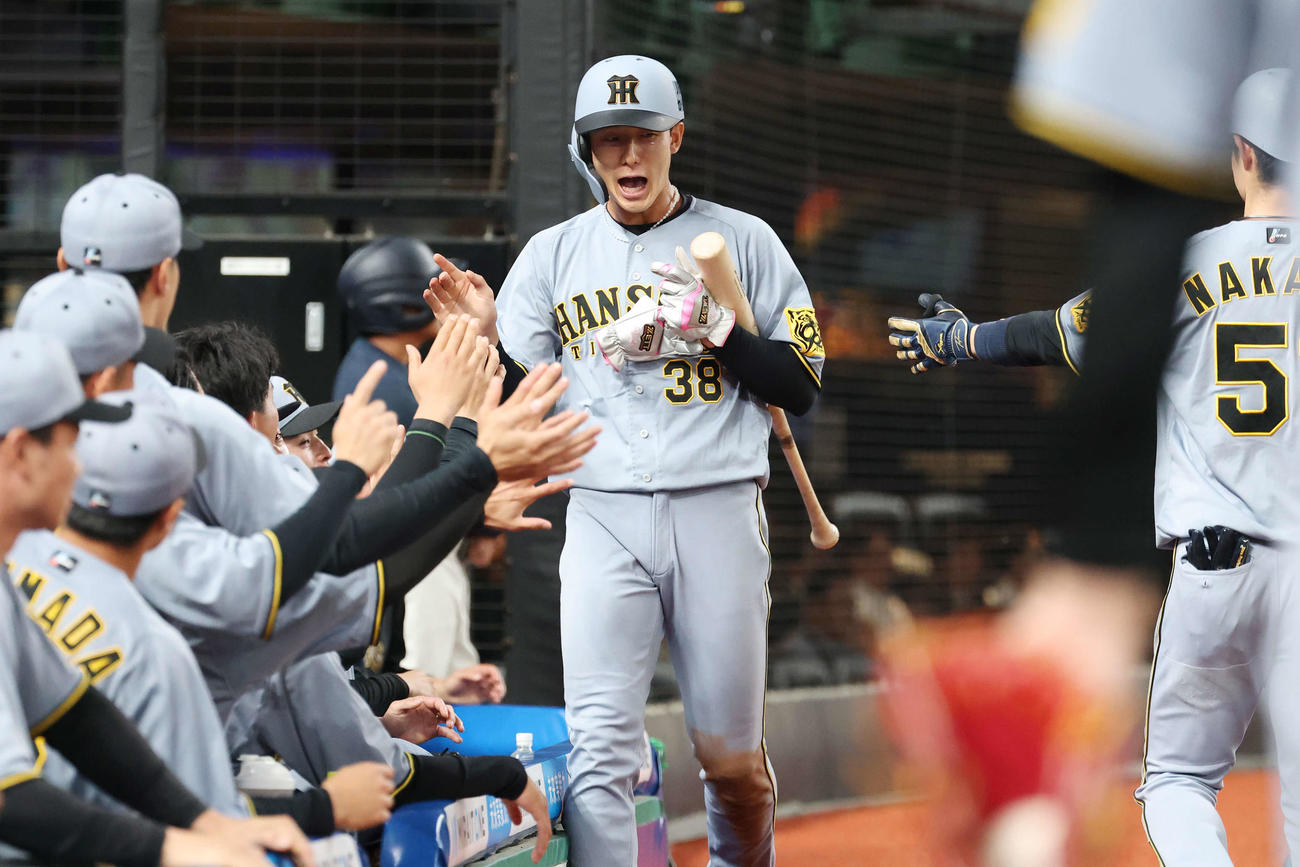 西武対阪神　2回表阪神2死一、三塁、熊谷の先制適時打で生還しタッチを交わす小幡（撮影・宮地輝）