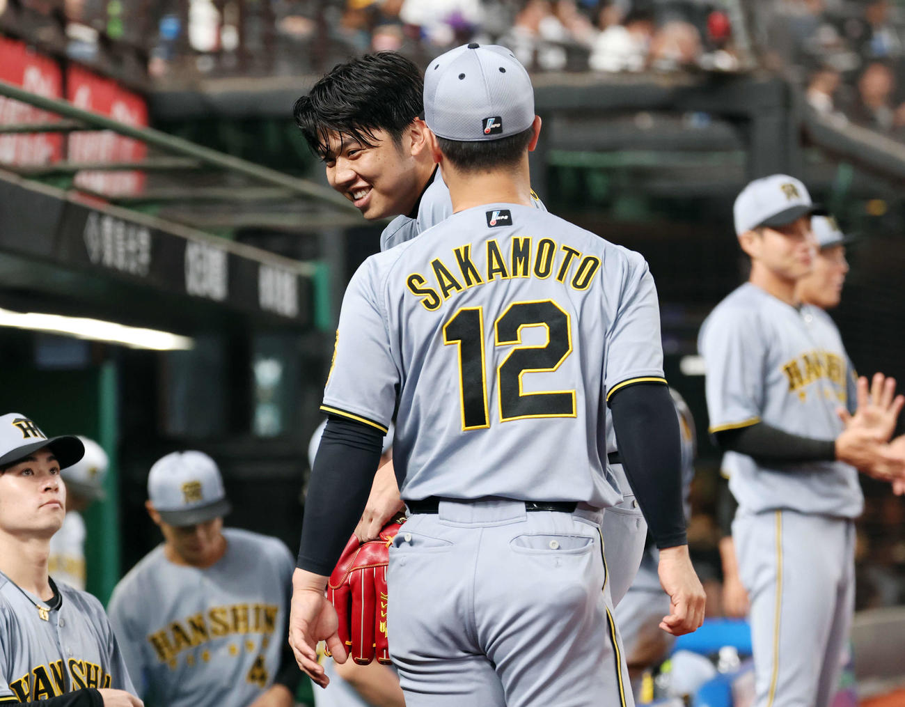 西武対阪神　4回裏を無失点に抑え阪神坂本（手前）に迎えられ笑顔を見せる才木（撮影・宮地輝）