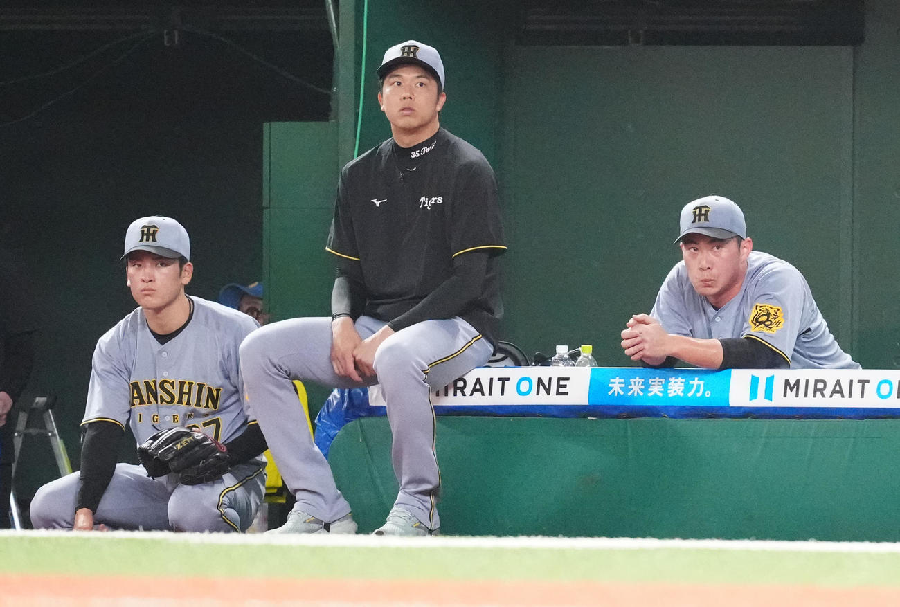西武対阪神　8回裏途中、交代しベンチで厳しい表情の阪神3番手桐敷（右）。中央は先発の才木（撮影・江口和貴）