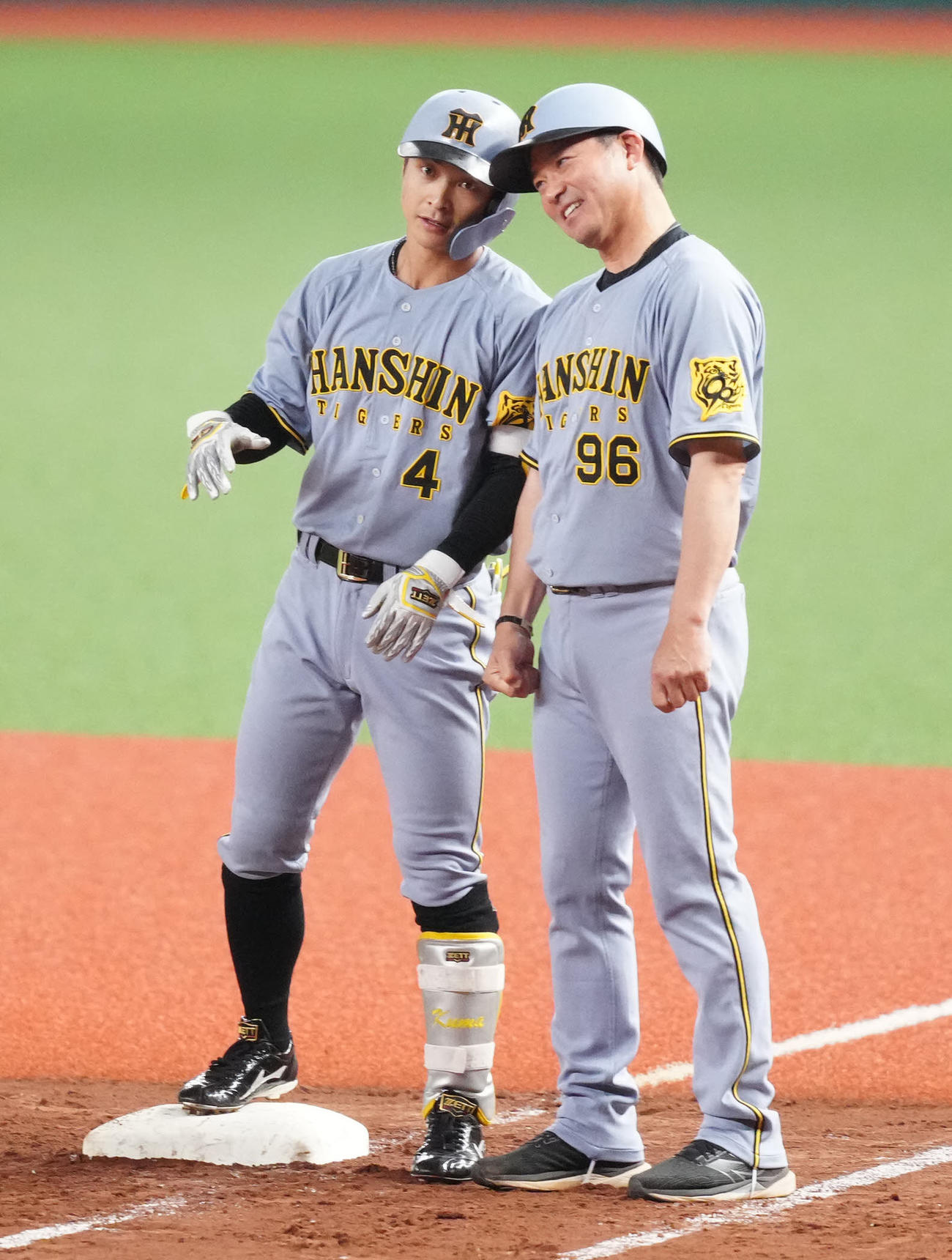 西武対阪神　2回表阪神2死一、三塁、先制適時打を放ち、筒井一塁ベースコーチ（右）とヘルメットタッチを交わす熊谷（撮影・江口和貴）