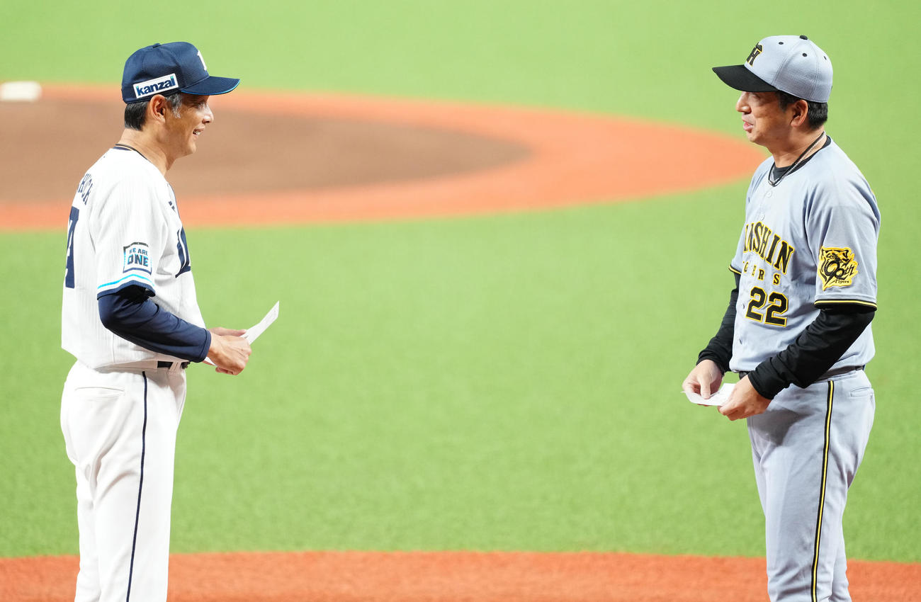 西武対阪神　試合前、メンバー表の最終確認を行う西武西口監督（左）と阪神藤川監督（撮影・江口和貴）