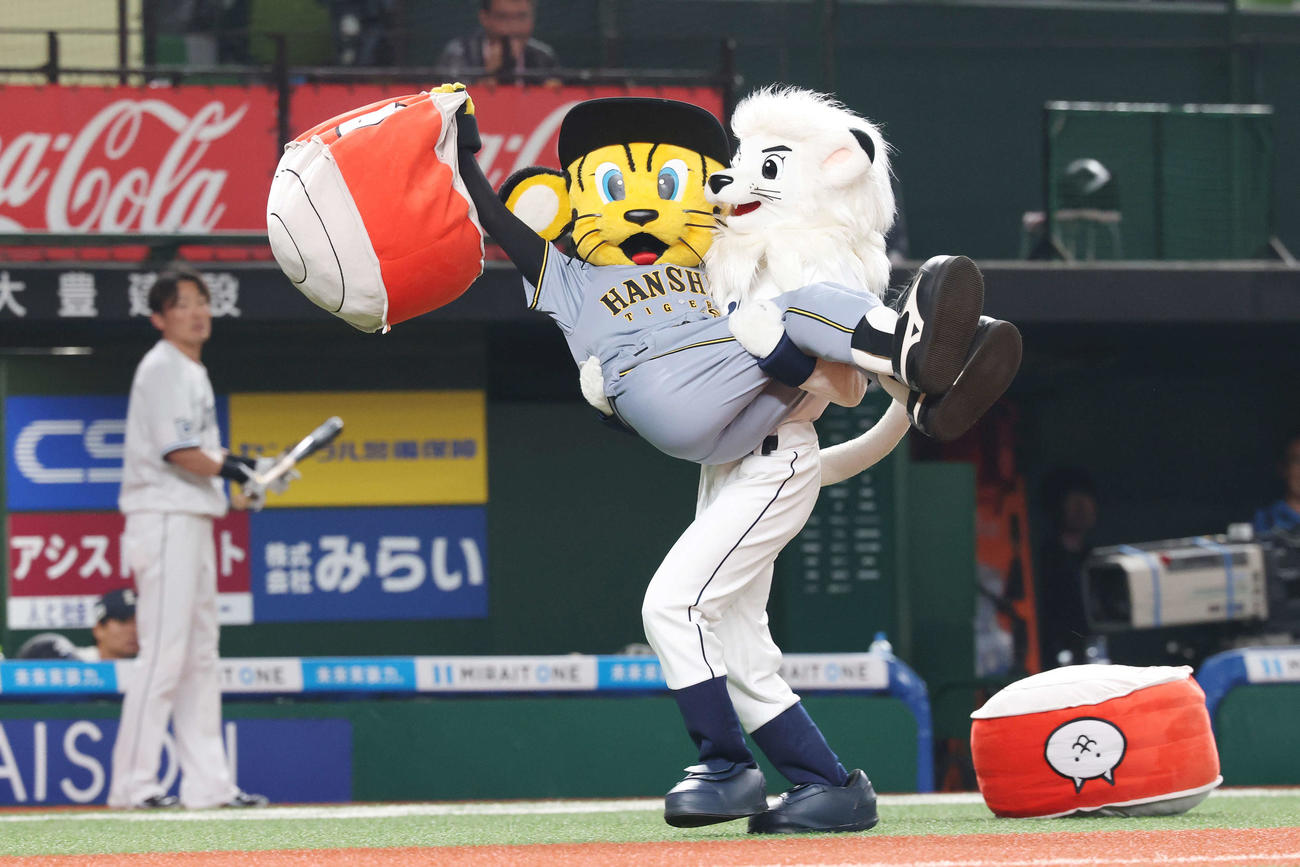 西武対阪神　トラッキー（左）を抱っこするレオ（撮影・宮地輝）