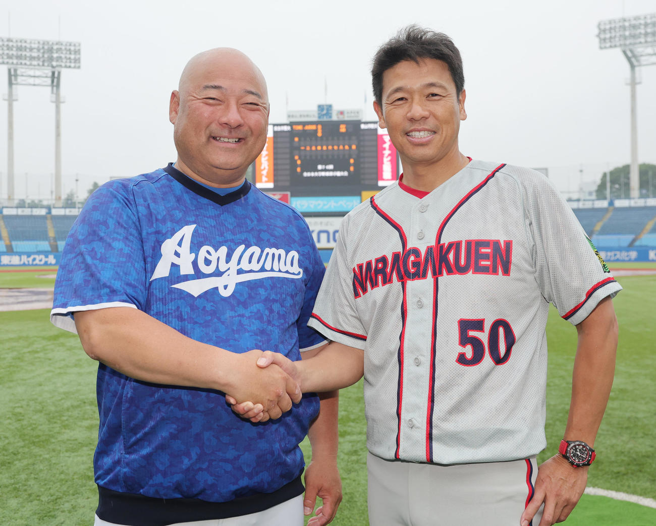 雨天中止が決まり、翌日の仕切り直しでの健闘を誓い合う青学大・安藤監督（左）と奈良学園大・酒井監督（撮影・野上伸悟）