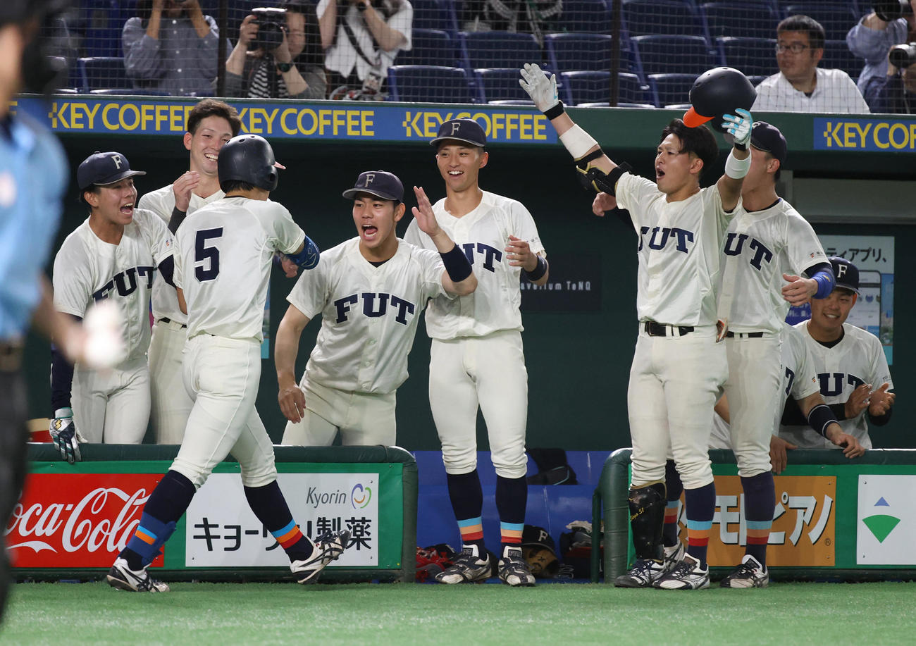 福井工大対大産大　2回表福井工大1死一、二塁、野口は右越えに本塁打を放ちナインの出迎えを受ける（撮影・柴田隆二）