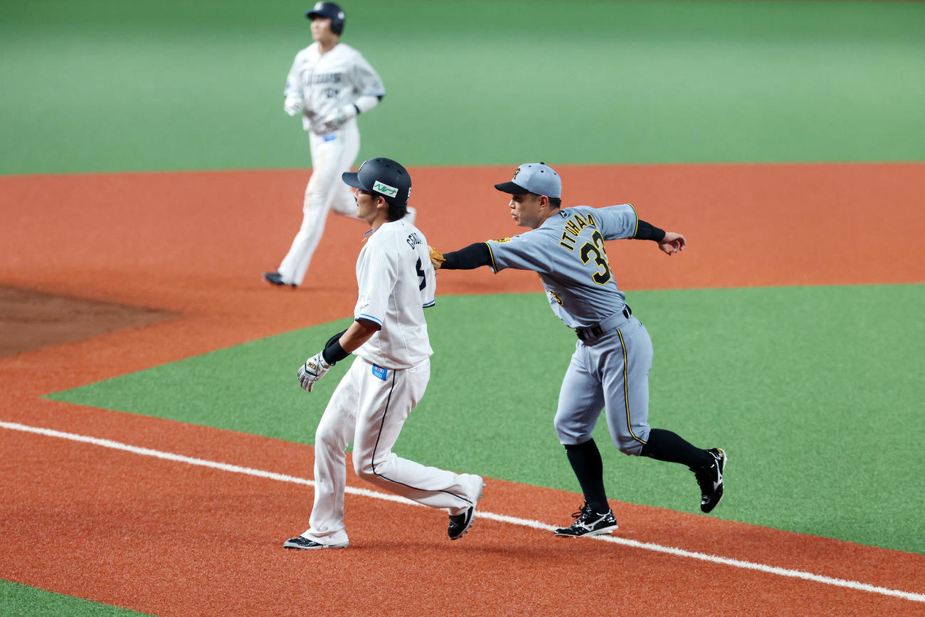 西武対阪神　2回裏西武2死一、三塁、三塁走者源田（左）をタッチアウトする糸原（撮影・宮地輝）