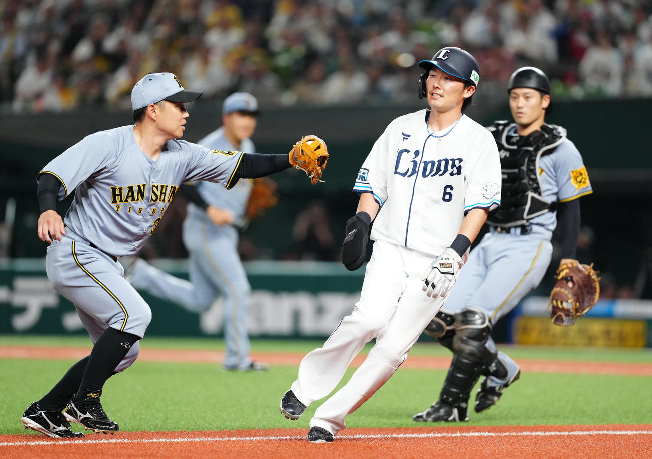 西武対阪神　2回裏西武2死一、三塁、挟殺される源田（中央）。左は三塁手糸原、右は捕手坂本（撮影・江口和貴）