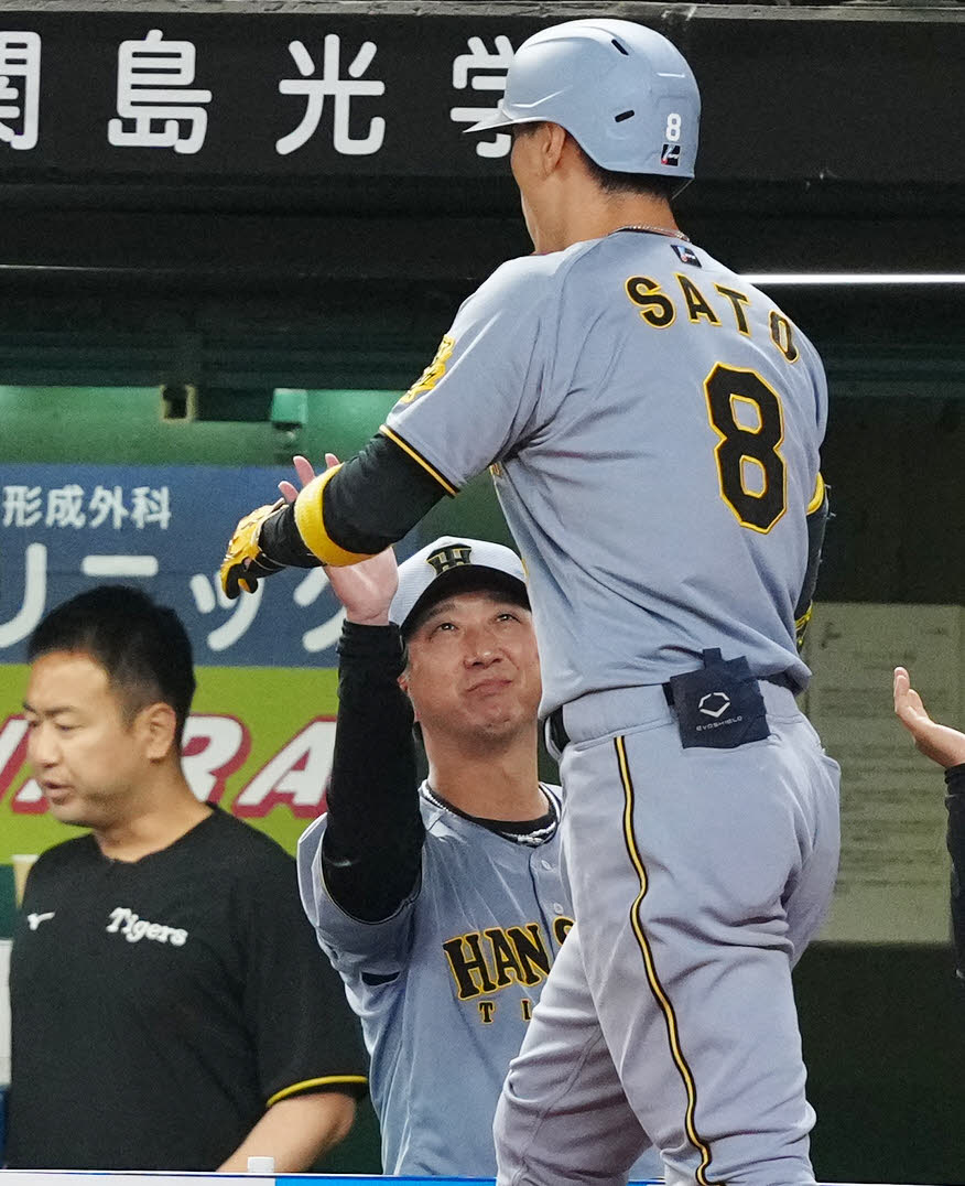 西武対阪神　9回表阪神無死、ソロ本塁打を放った佐藤輝（右）とタッチを交わす藤川監督（撮影・江口和貴）
