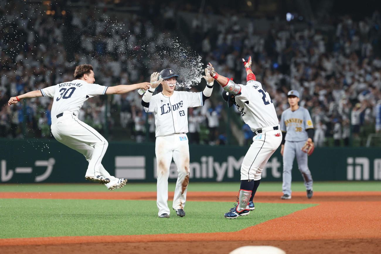 西武対阪神　9回裏西武2死満塁、サヨナラ右前適時打を放ちチームメートからウオーターシャワーを浴びる炭谷（右）（撮影・宮地輝）