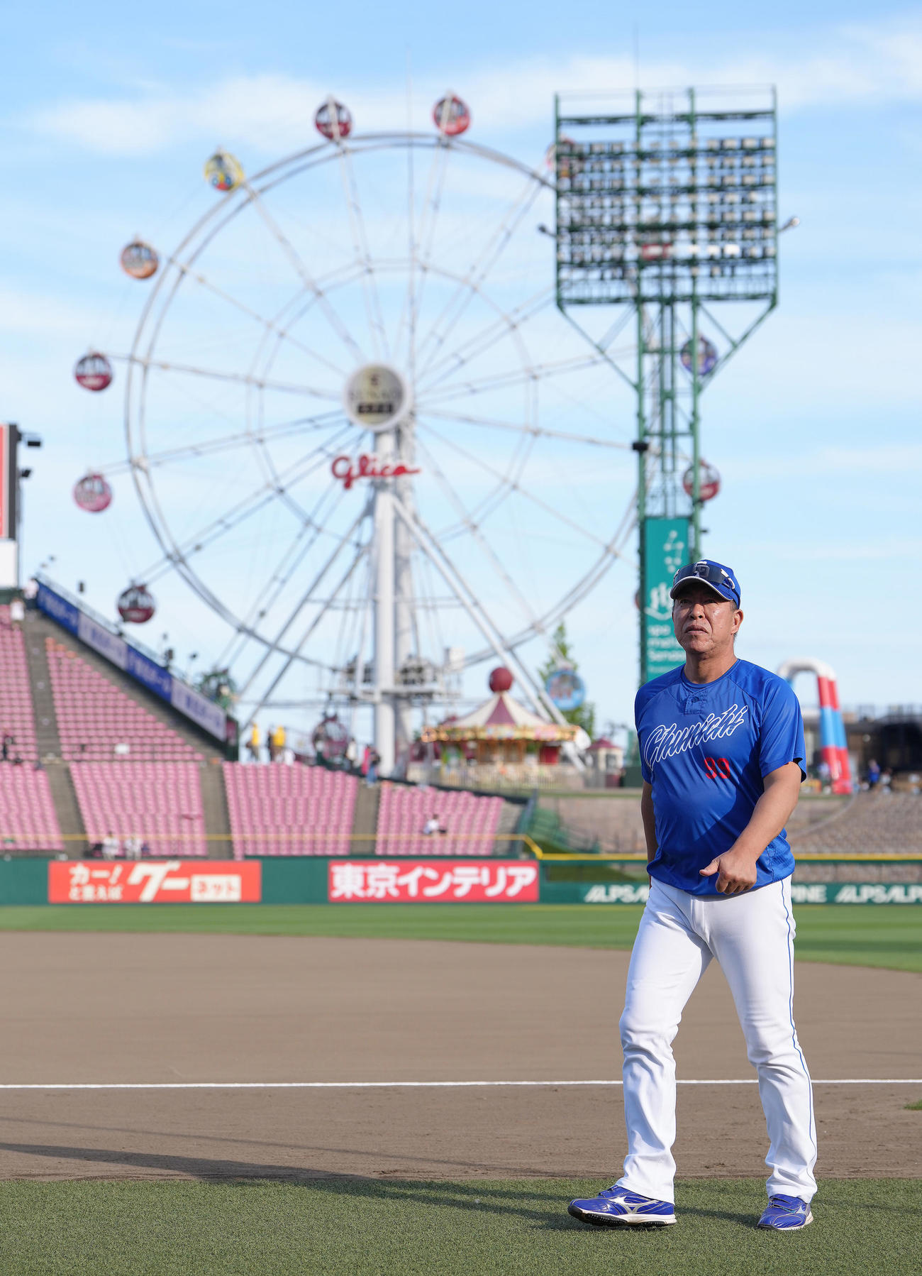観覧車を背に、試合前の練習を見つめる中日井上監督（撮影・足立雅史）
