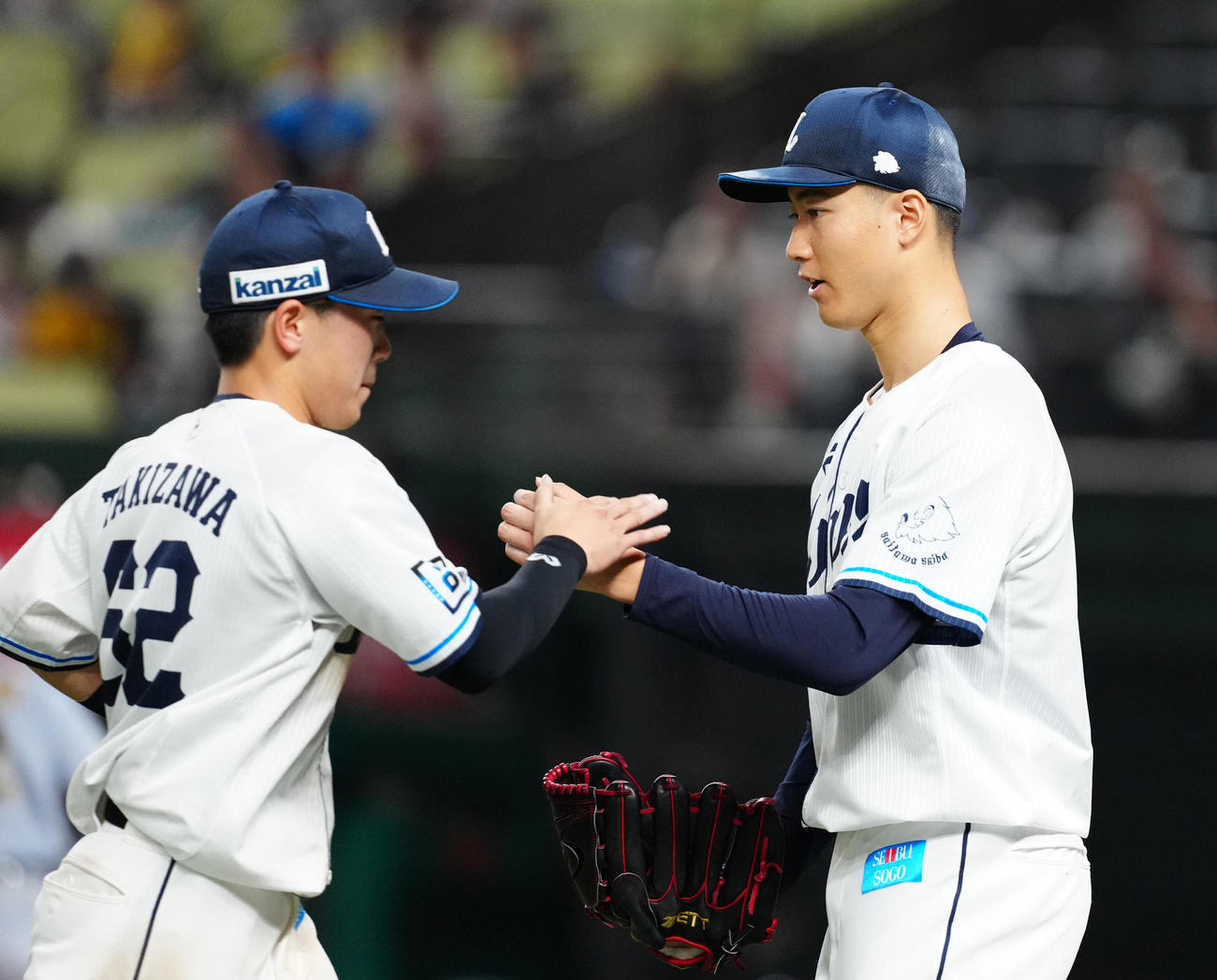 西武対阪神　3回表終了後、西武二塁手滝沢（左）とタッチを交わす先発の菅井（撮影・江口和貴）