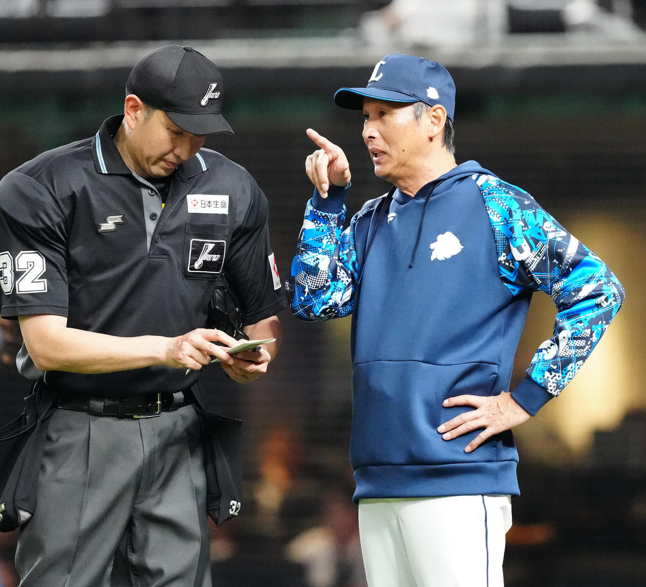 西武対阪神　5回裏終了後、選手交代を告げる西武西口監督（右）（撮影・江口和貴）