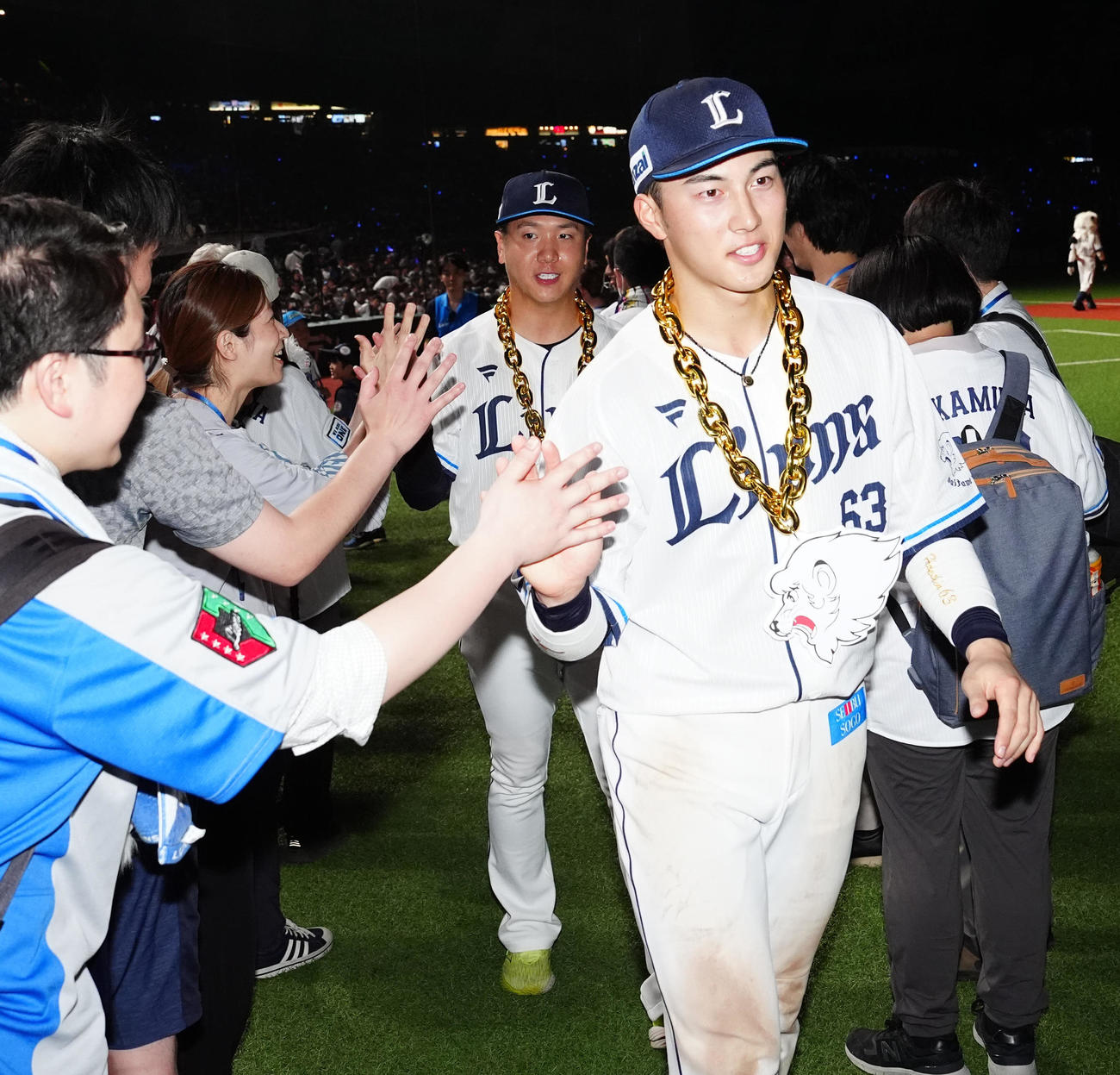 西武対阪神　試合後、ファンとタッチを交わす西武長谷川（手前）と平沼（撮影・江口和貴）