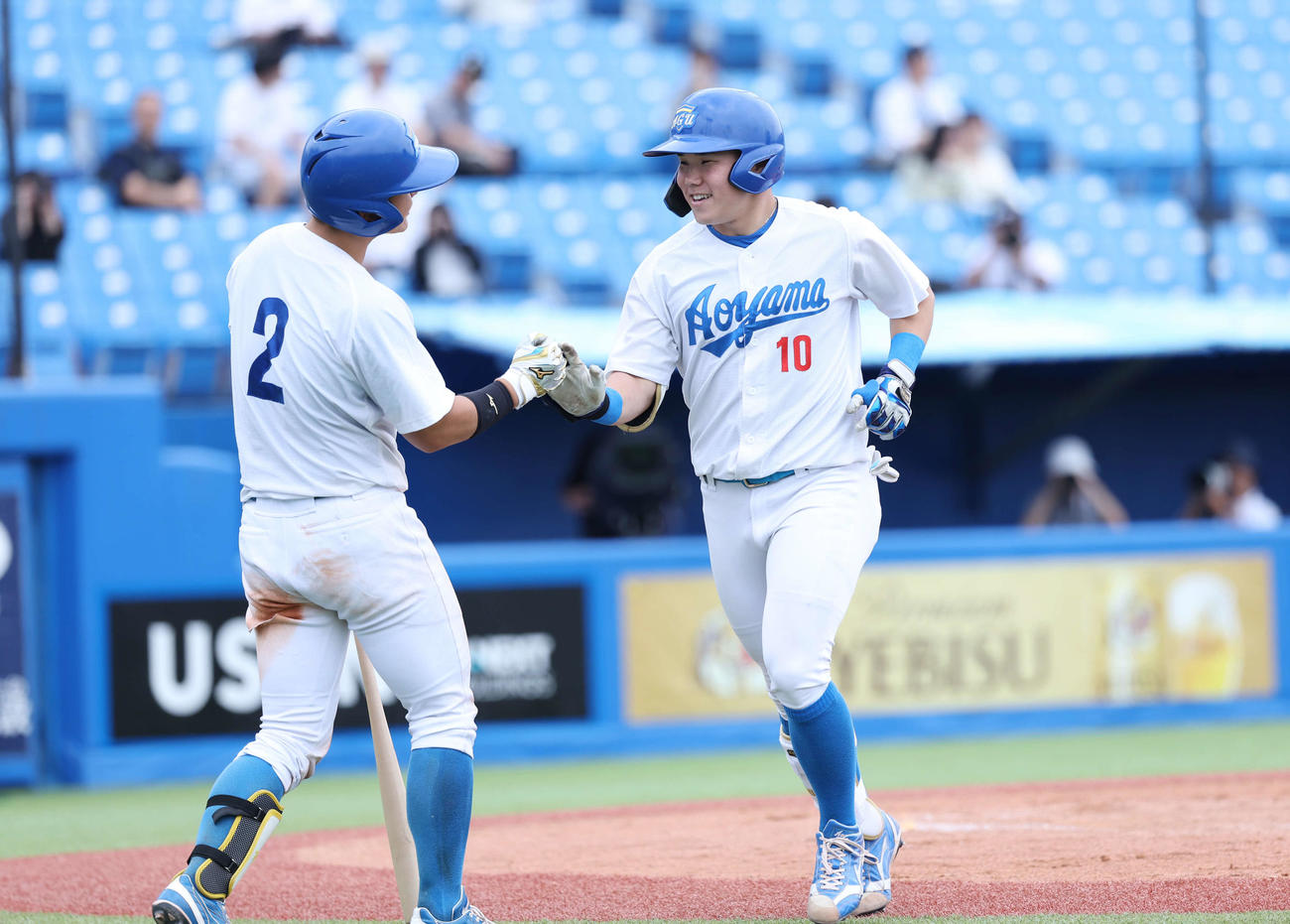 青学大対北海学園大　7回表青学大1死一塁、左柵越え本塁打を放ち生還しタッチを交わす小田（右）（撮影・増田悦実）