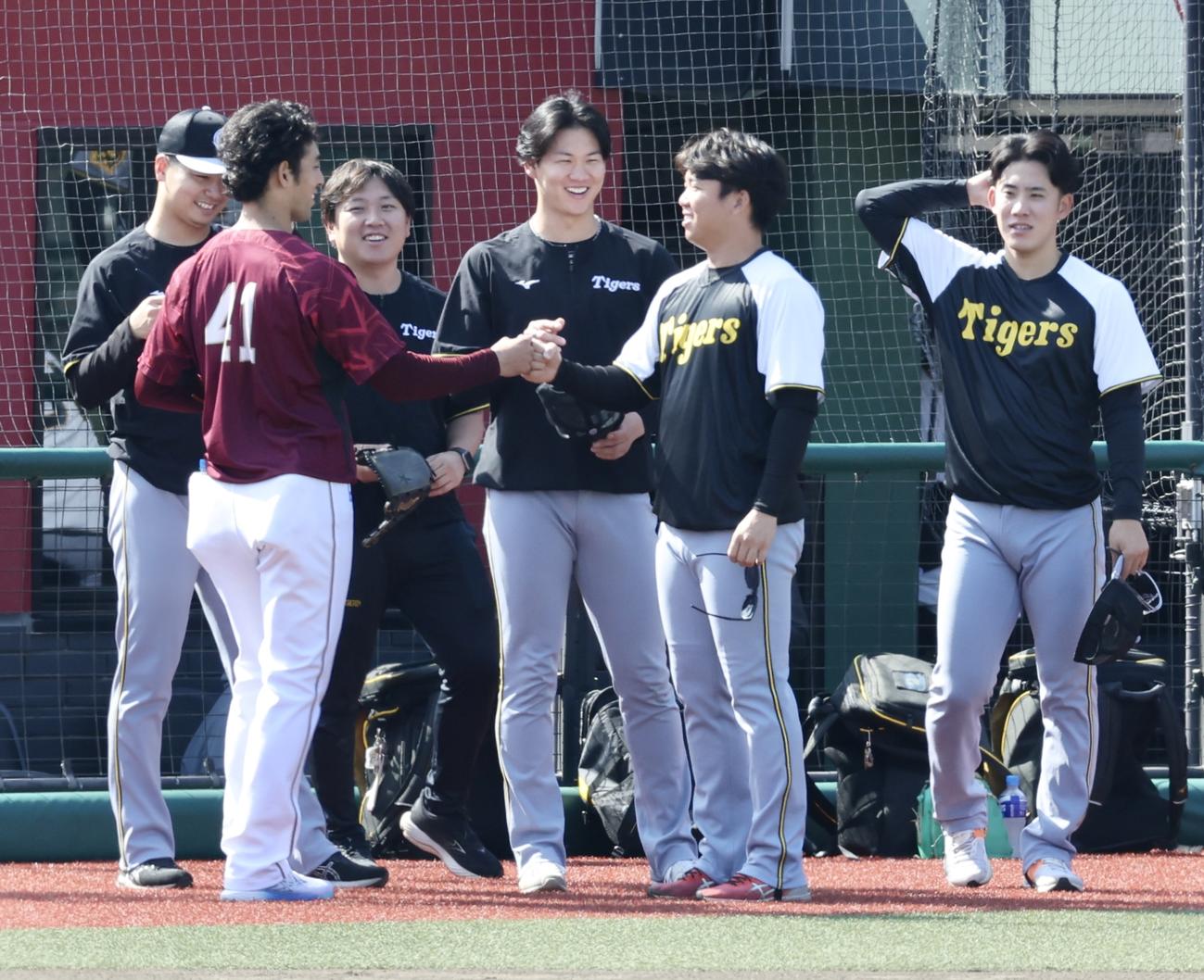 楽天対阪神　試合前、あいさつを交わす楽天加冶屋（左）と村上ら阪神ナイン（撮影・河田真司）