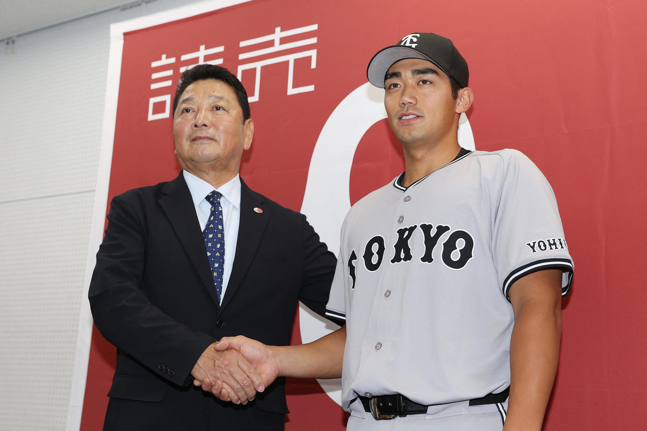 支配下契約を結び、吉村編成本部長（左）と握手を交わす巨人三塚（撮影・前田充）