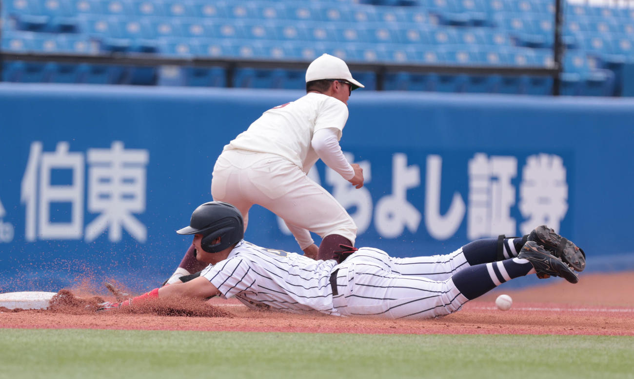 東海大対早大　4回表東海大2死一、二塁、笹田は左中間に適時三塁打を放ちヘッドスライディングする。田村三塁手（撮影・柴田隆二）