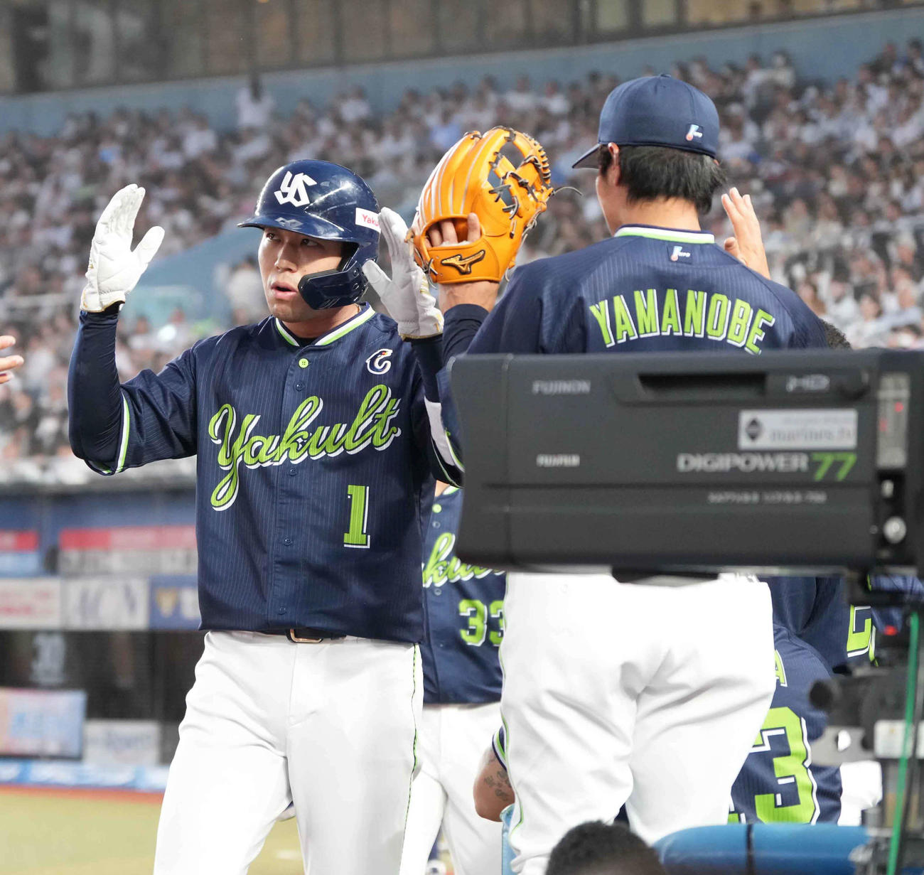 ロッテ対ヤクルト　4回表ヤクルト2死二塁、伊藤の逆転2点中適時打で生還した山田（左）はベンチのナインの祝福を受ける（撮影・小沢裕）