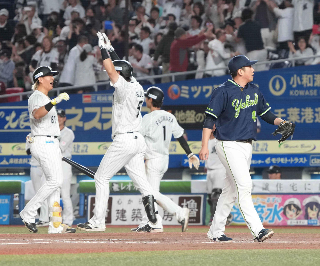 ロッテ対ヤクルト　9回裏ロッテ1死二、三塁、ヤクルト5番手で登板した大西（右）は暴投でサヨナラ勝ちを喫し、大喜びするロッテナインを背に引き揚げる（撮影・小沢裕）