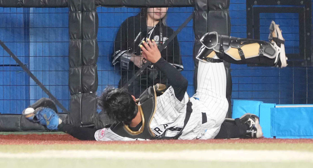 ロッテ対ヤクルト　8回表ヤクルト1死、内山のフェンス際の邪飛を好捕するロッテ田村捕手（撮影・小沢裕）