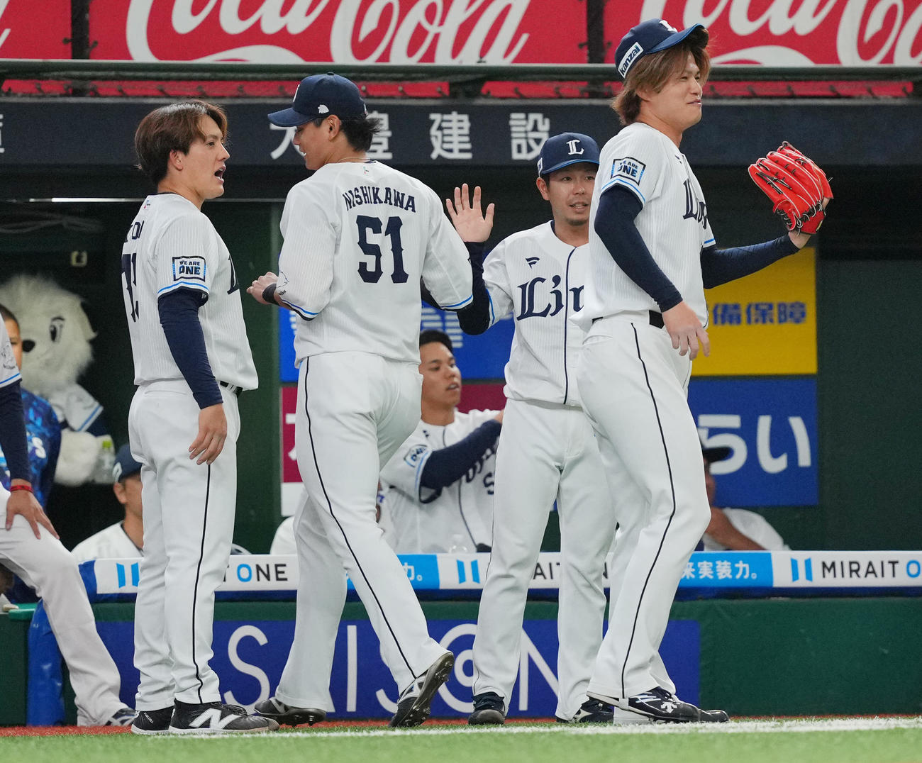 西武対中日　7回表中日の攻撃を無失点に抑えた西武与座（左）と甲斐野（右）は笑顔でナインとタッチを交わす（撮影・垰建太）