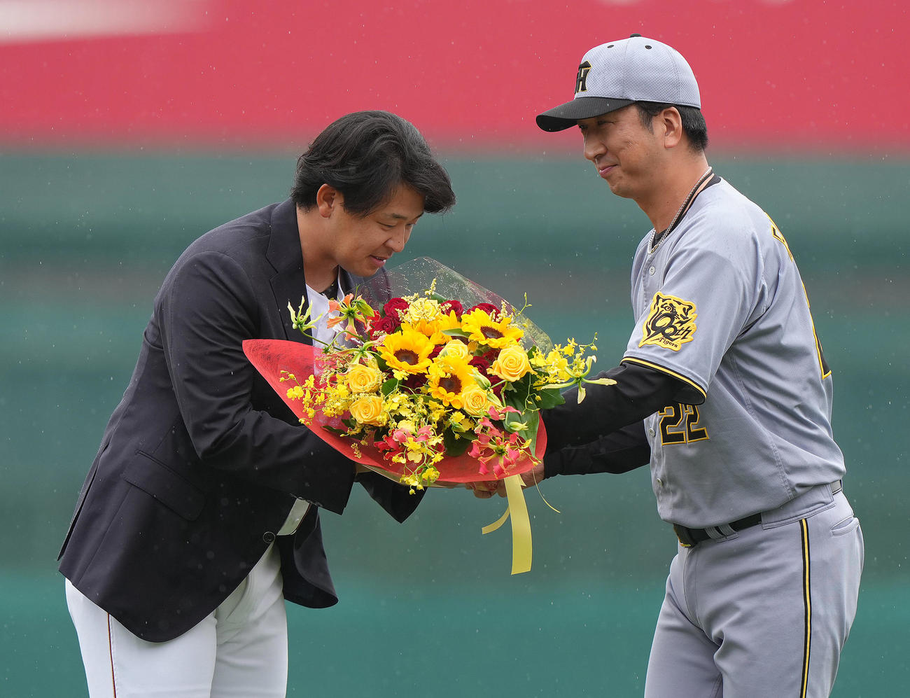 名球会入りのブレザー授与式に臨んだ楽天浅村（左）は阪神藤川監督から花束を受け取る（撮影・足立雅史）