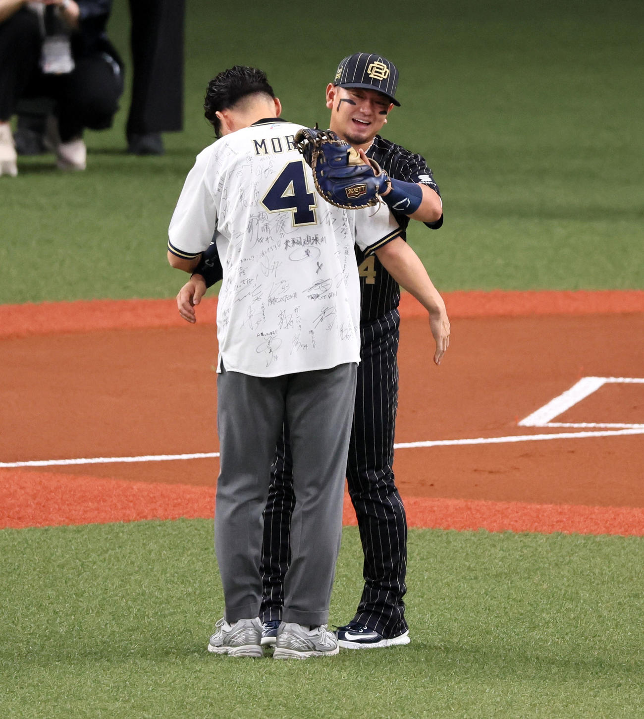 オリックス対巨人　特別始球式を行った福森大翔さん（左）とボール受けハグする親友の森（撮影・加藤哉）