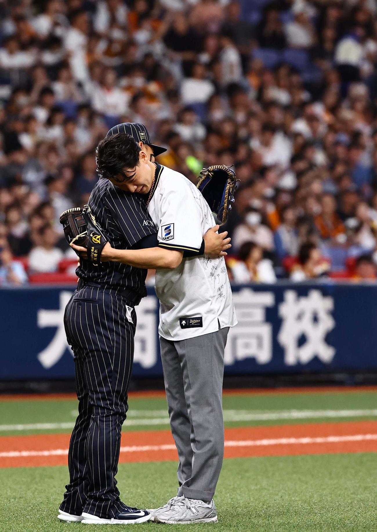 オリックス対巨人　プレ始球式を務める大阪桐蔭OBの福森大翔さん（右）は捕手を務めた森と抱き合う（撮影・上田博志）