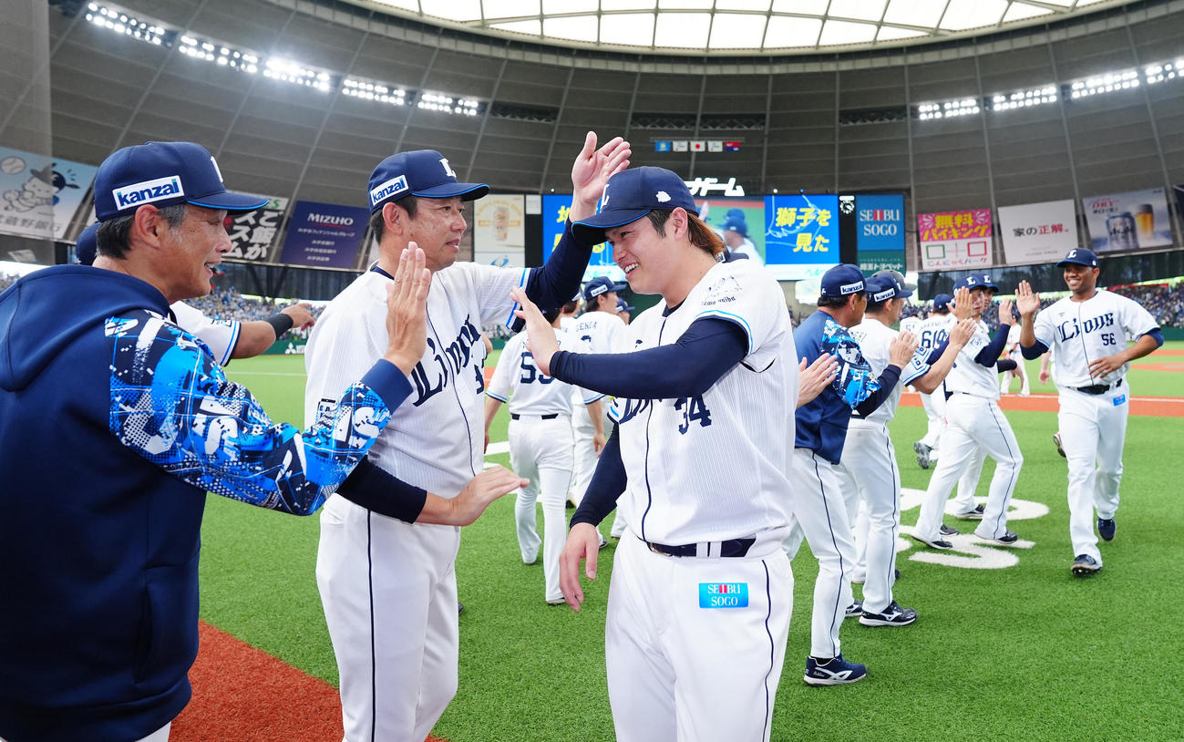 西武対中日　中日に勝利し西口監督（左）とタッチを交わす西武甲斐野（撮影・垰建太）