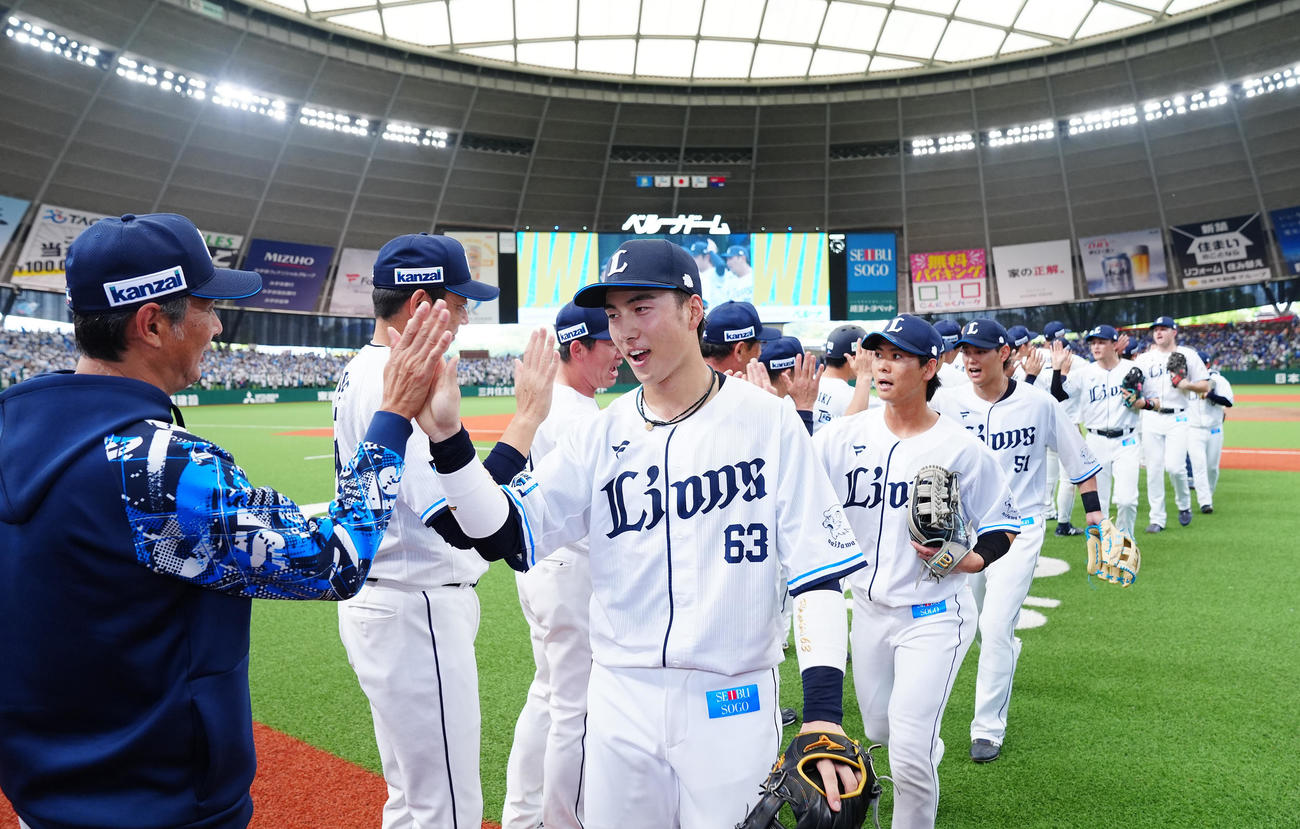 西武対中日　中日に勝利し西口監督（左）と笑顔でタッチを交わす長谷川（中央）ら西武ナイン（撮影・垰建太）