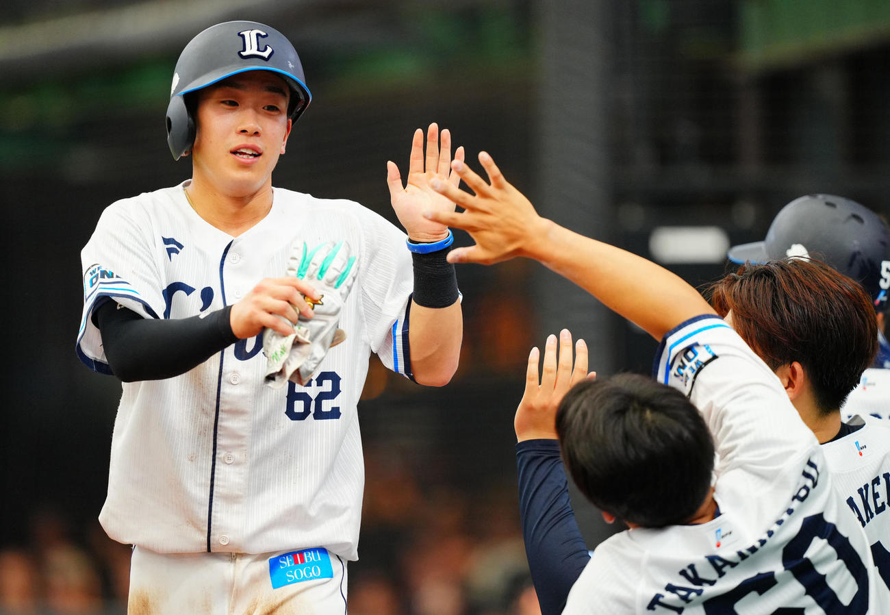 西武対中日　6回裏西武1死一塁、長谷川の適時二塁打で生還しナインの出迎えを受ける滝沢（撮影・垰建太）