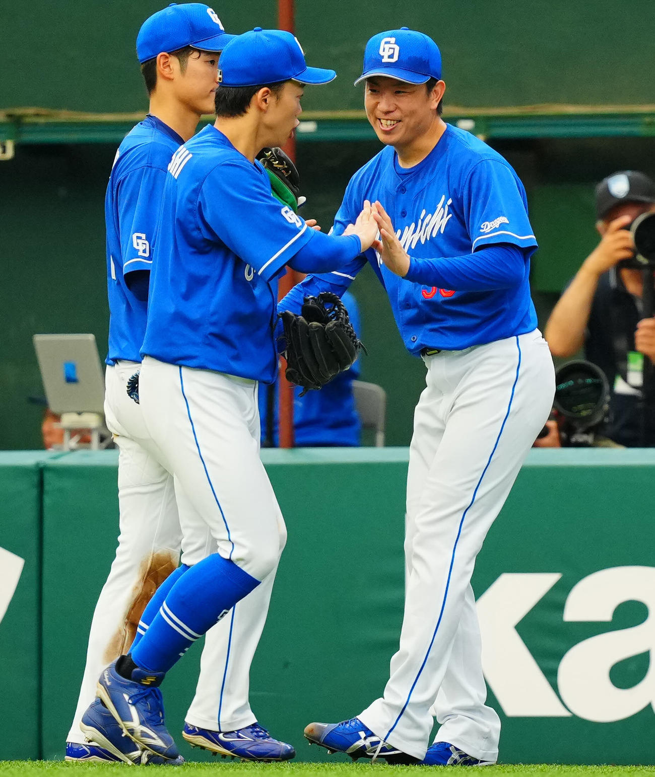 西武対中日　7回裏西武の攻撃を無失点に抑えた中日先発の松葉（右）は岡林（中央）らナインと笑顔でタッチ（撮影・垰建太）