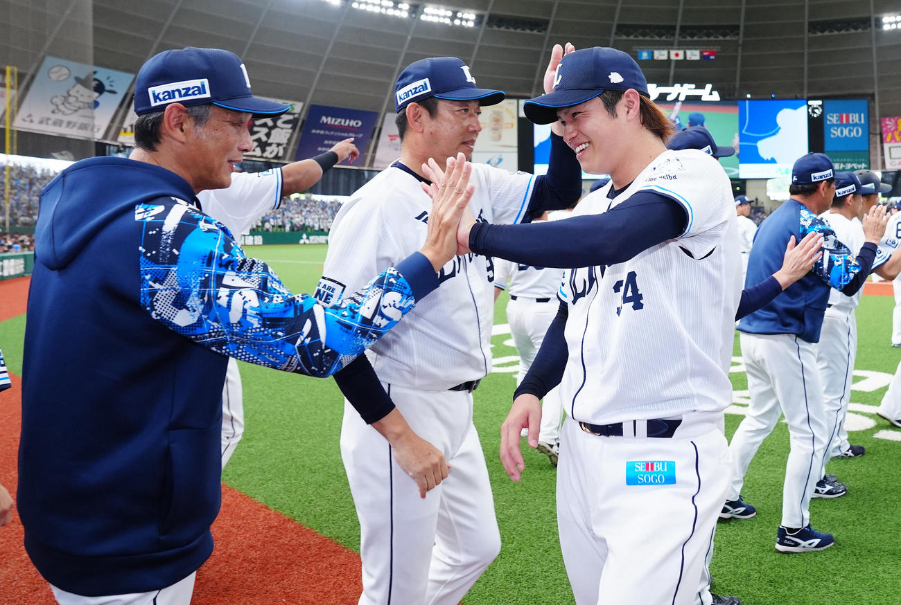 西武対中日　中日に勝利し西口監督（左）とタッチを交わす西武甲斐野（撮影・垰建太）