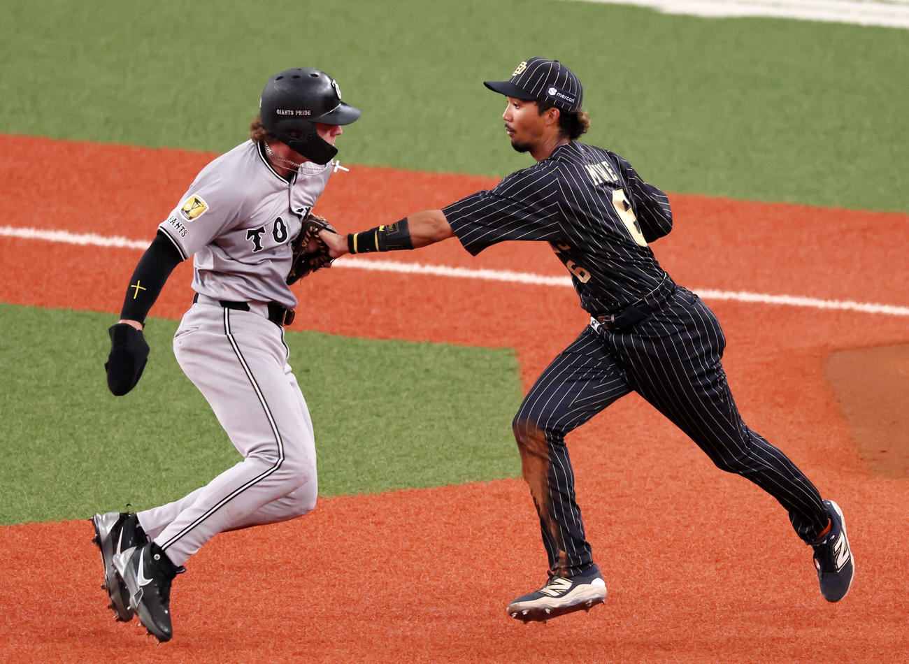 オリックス対巨人　7回表巨人1死一、二塁、一塁走者キャベッジは甲斐拓也の中前適時打で二・三塁間に挟まれ宗（右）にタッチされアウトになる（撮影・加藤哉）